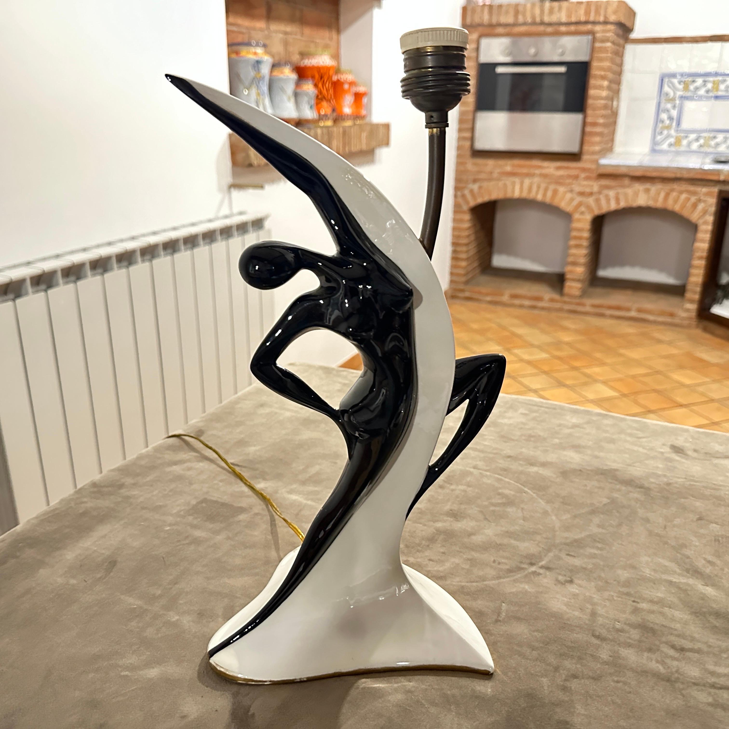 This lamp is a classic example of Mid-Century Modern design, created by the Italian artist Italo Casini in the 1960s. The ceramic lamp showcases an elegant, fluid form that captures movement, almost like a stylized sculpture. It features a