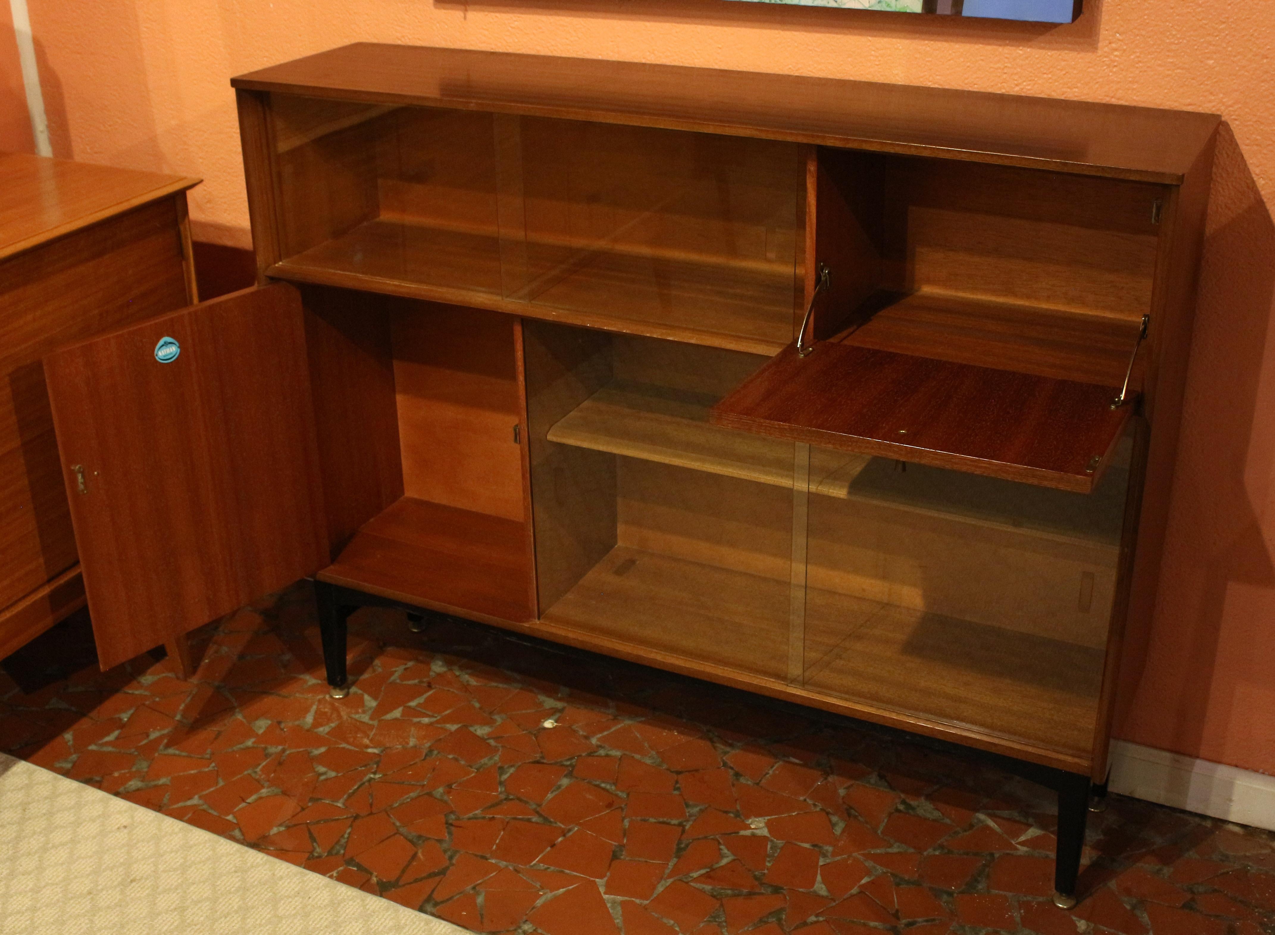 Librería o mueble buffet moderno de mediados de siglo de 1960, Nathan, Inglaterra. Puertas correderas de cristal superiores e inferiores opuestas con armario con puerta abatible superior derecha e inferior izquierda. Etiqueta 
