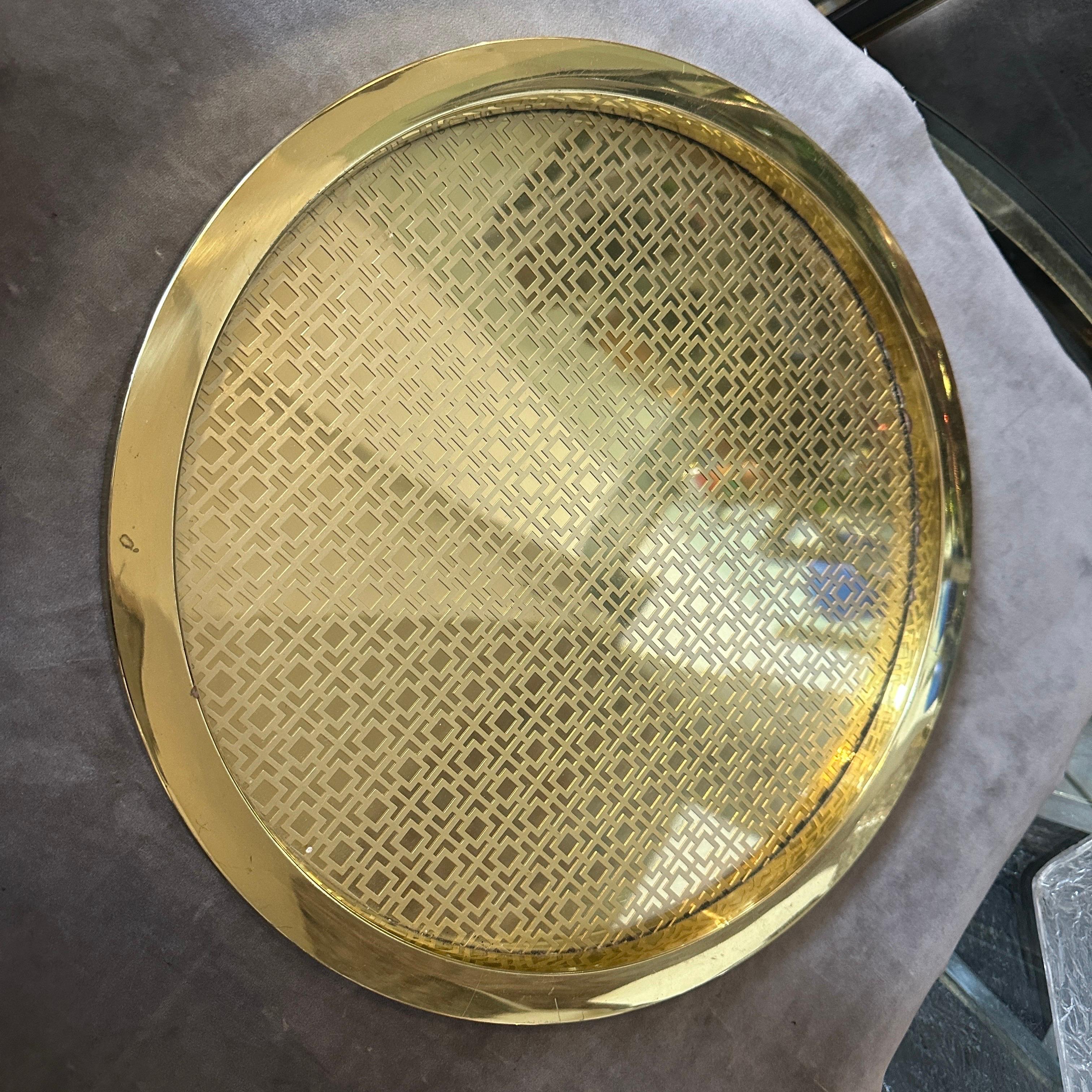 Chic 1960s Mid-Century Modern Italian Round Serving Tray - Brass with Geometric Pattern & Glass Top
Introduce a touch of timeless sophistication to your home with this exquisite round serving tray, originating from Italy in the 1960s. This piece is