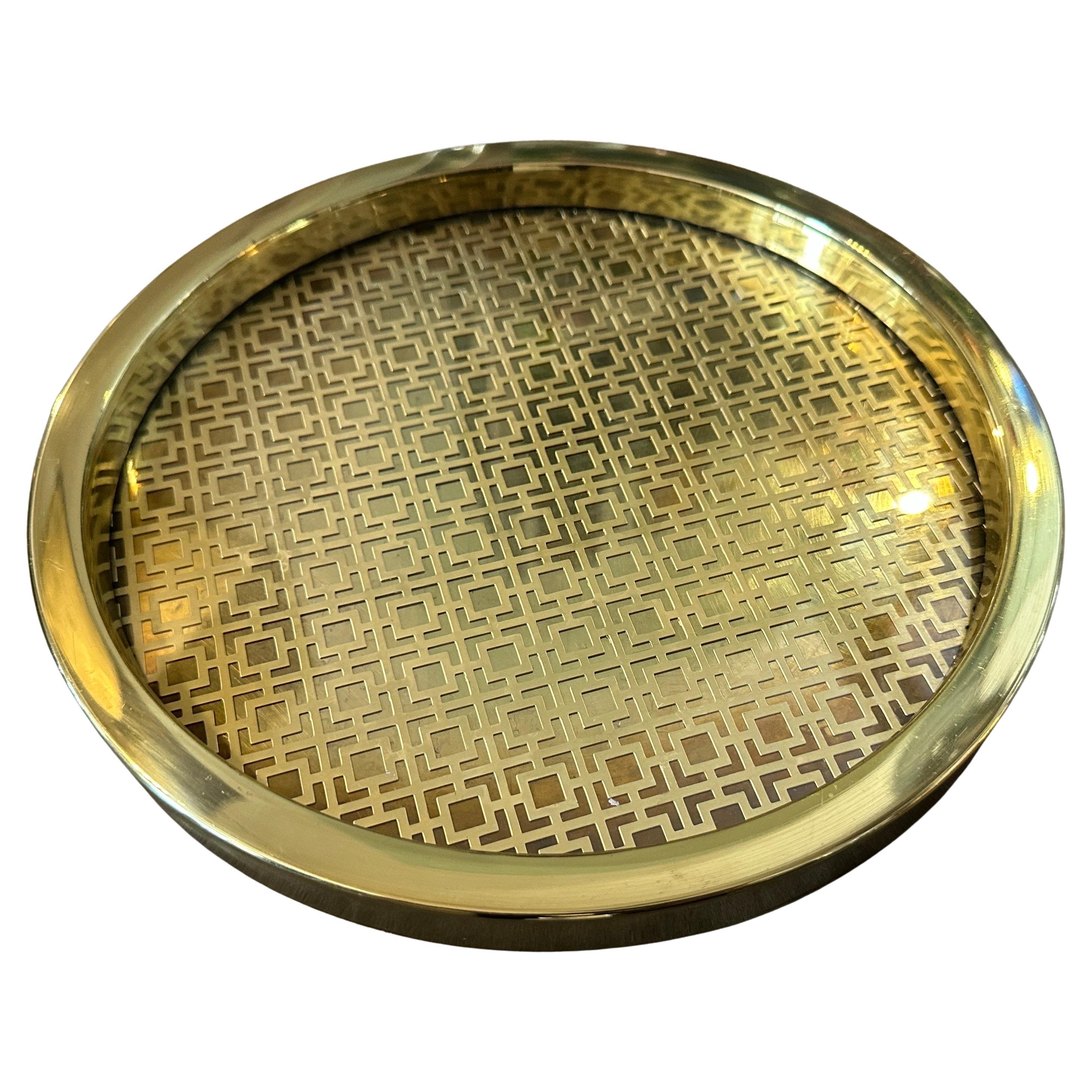Chic 1960s Mid-Century Modern Italian Round Serving Tray - Brass with Geometric Pattern & Glass Top
Introduce a touch of timeless sophistication to your home with this exquisite round serving tray, originating from Italy in the 1960s. This piece is