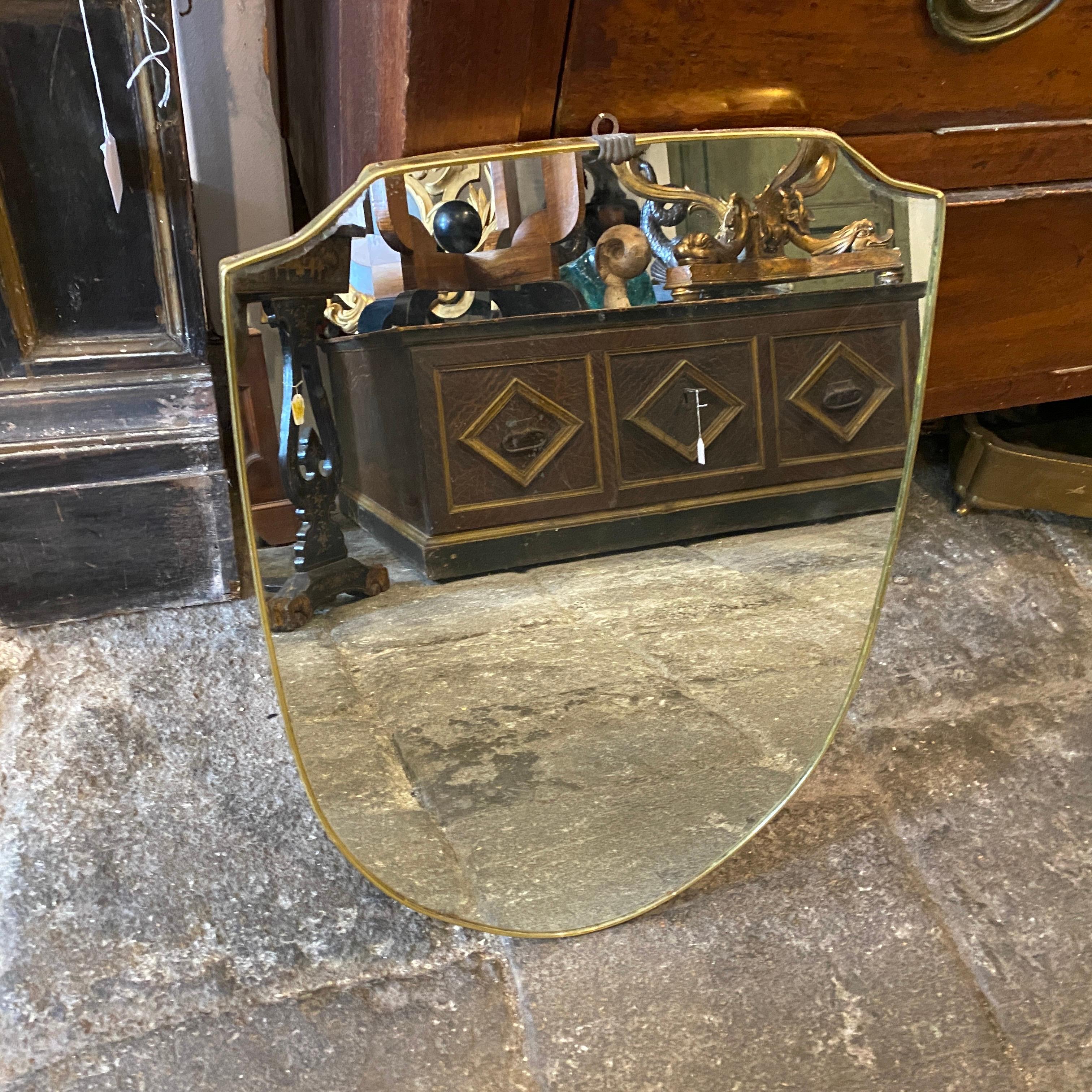 A shield wall mirror made in Italy in the 1960s, good conditions overall, signs of use and age.