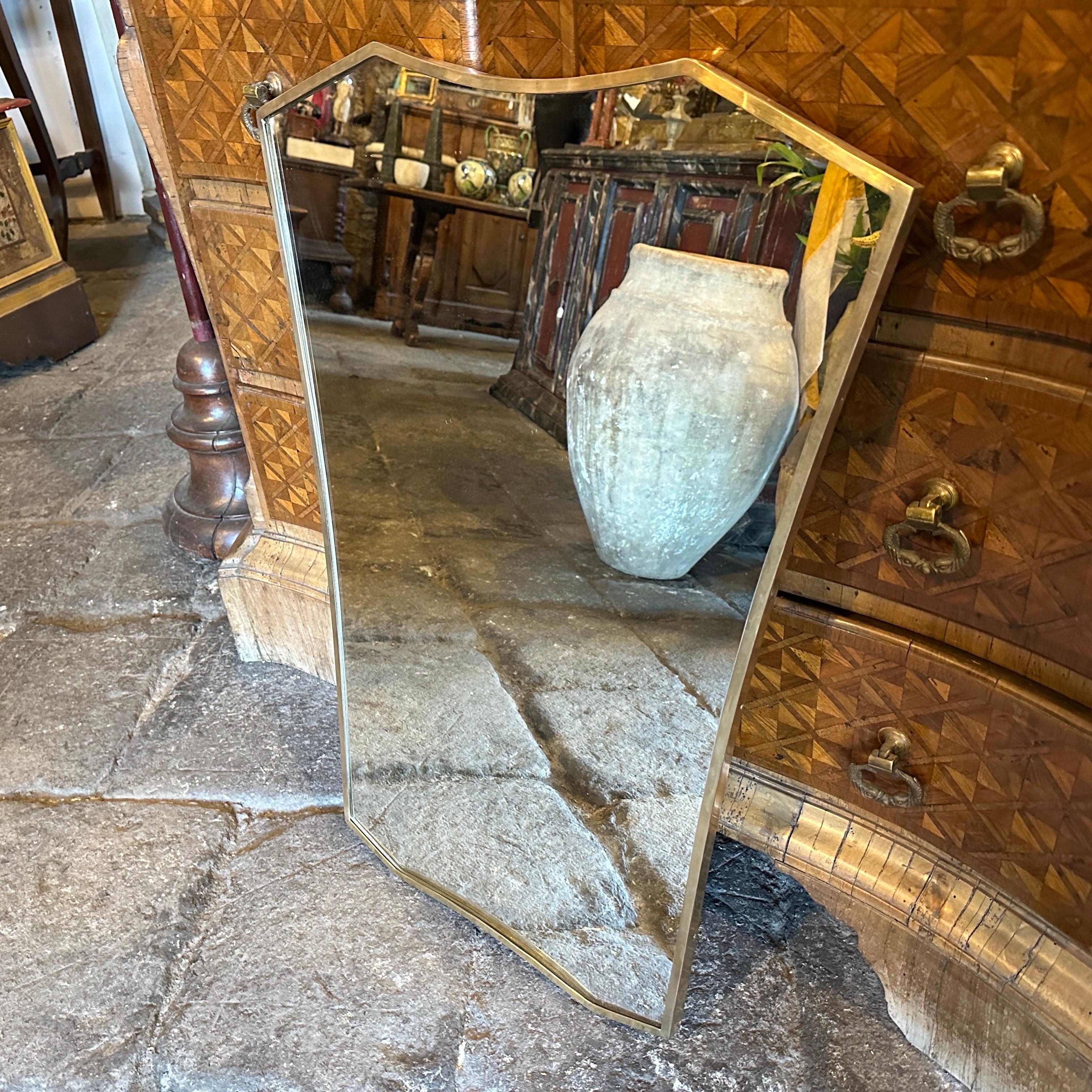 An amazing mid-century modern, well-shaped, solid brass wall mirror handcrafted in Italy in the Fifties in the manner of Gio Ponti, who used these wall mirrors to furnish the most prestigious homes in Milan in the 1950s. The mirror is in its