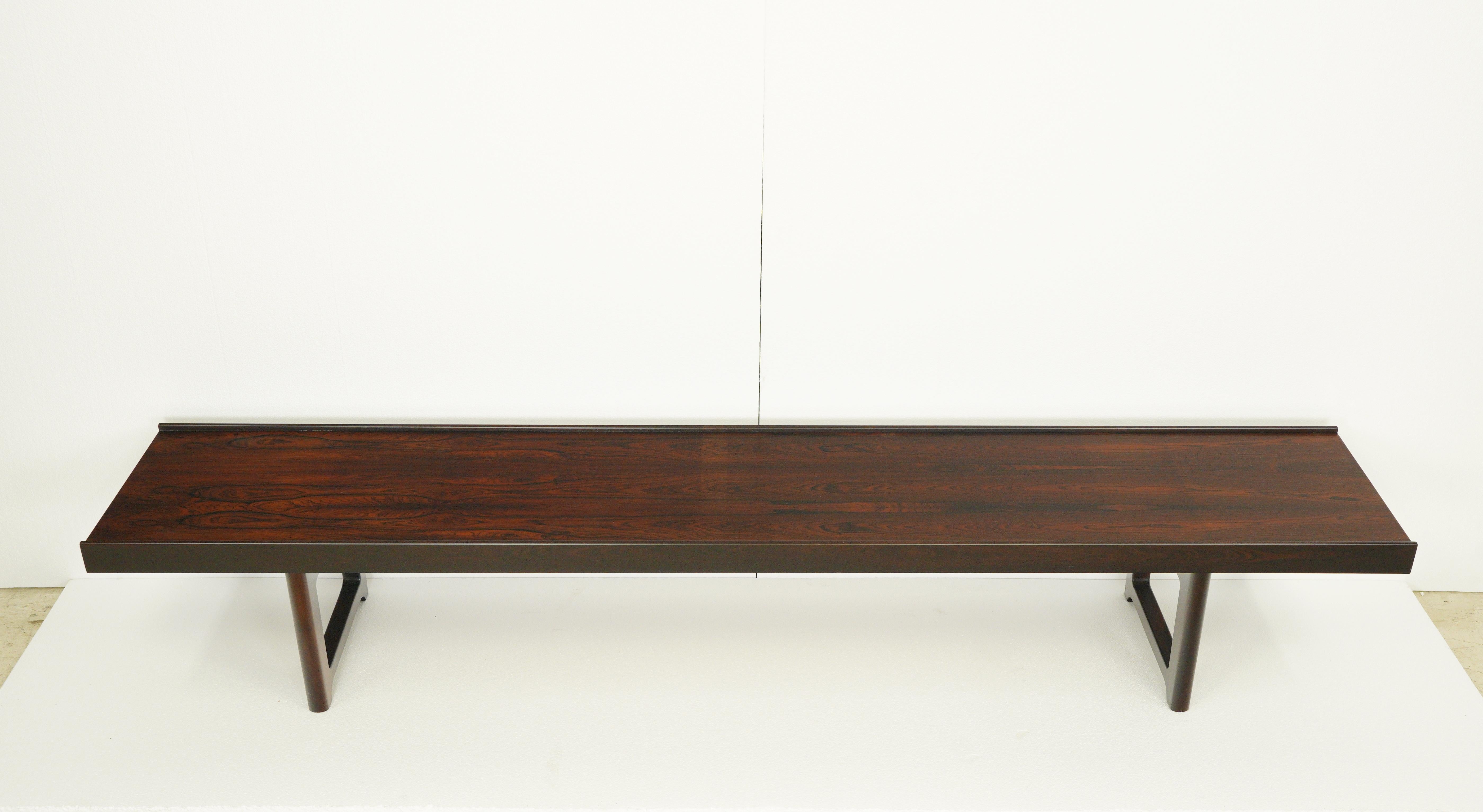 Made in Norway by Mellemstrands Trevareindustri. Designed by Torbjorn Afdal. This long bench is made of rosewood with black iron strapping. It can also be used as a coffee table. In excellent condition. One of the side pieces has a minor repair.