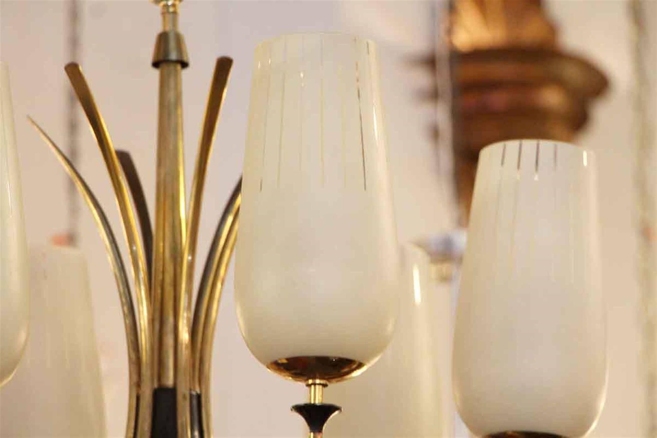 1960s Mid-Century Modern six-arm chandelier with white and clear stripe shades. Shown in a polished brass finish. This can be seen at our 2420 Broadway location on the upper west side in Manhattan.