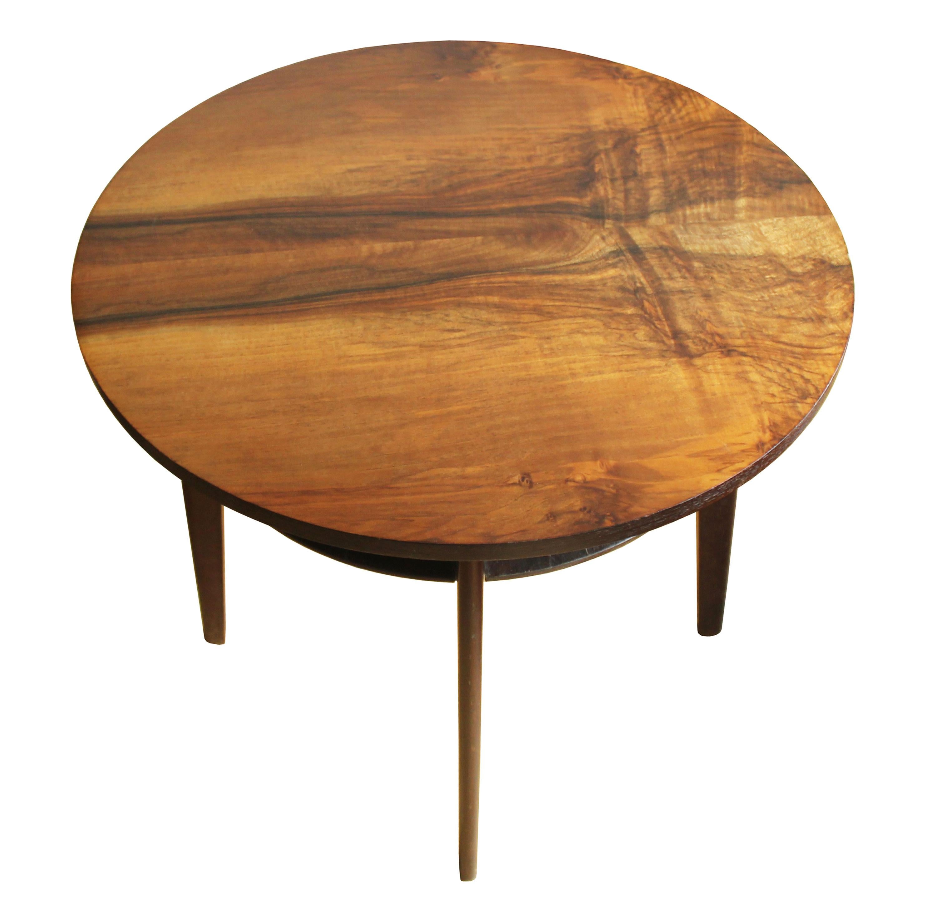 This round coffee table was designed and produced in 1960’s Czechoslovakia. It consists of four tampered legs, a circular tabletop with striking walnut veneer texture and another round thin beechwood layer underneath the main tabletop. At the time,