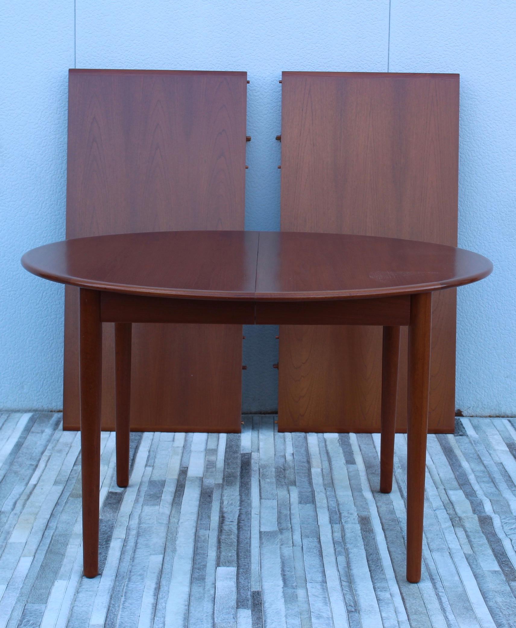 Stunning 1960's Mid-Century Modern round teak Danish dining table with two leaves, fully restored with minor wear and patina due to age and use.

Each leave is 23.5'' wide table without the leaves is 48'' diameter.