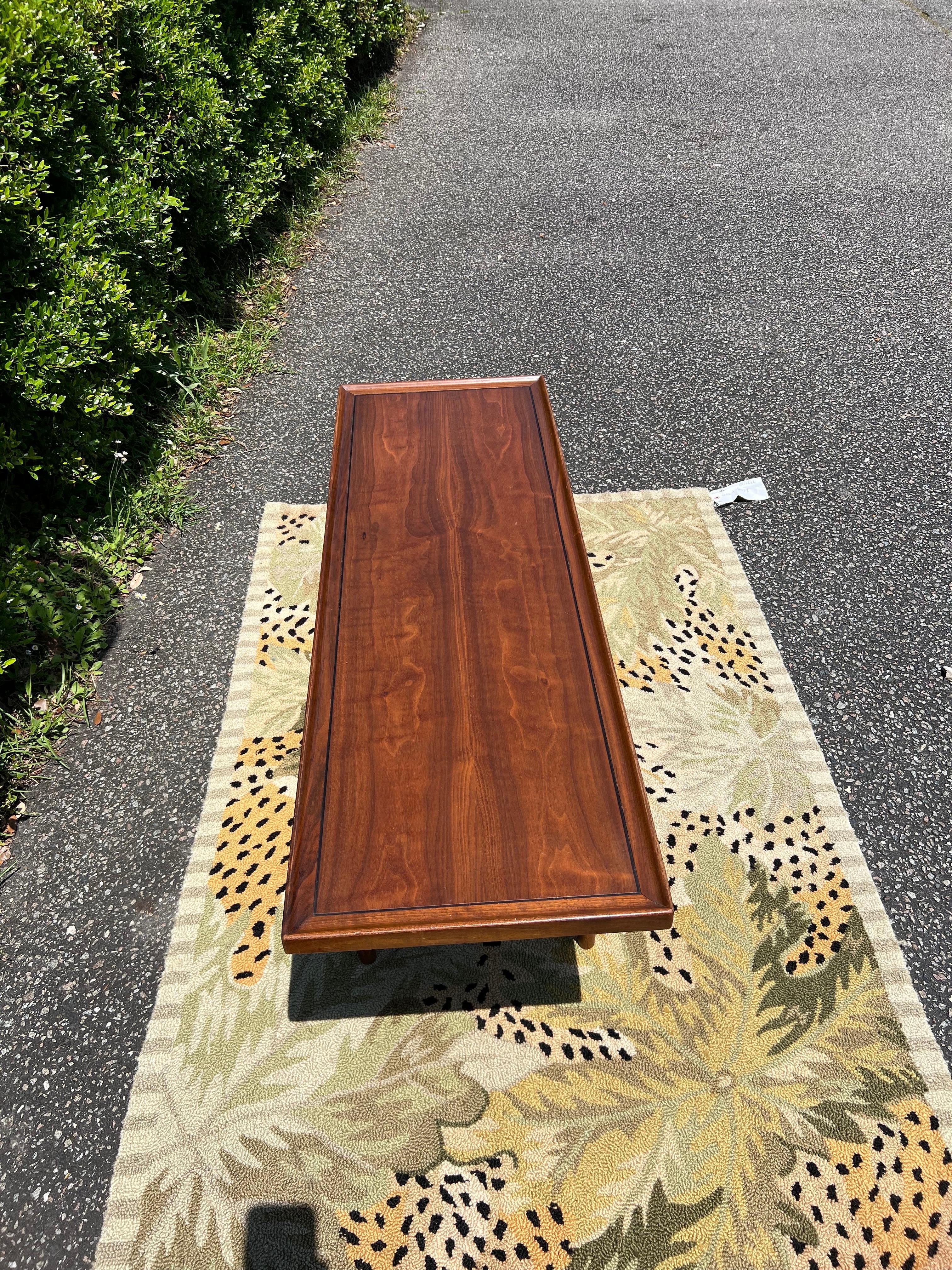Table basse de style moderne danois au design épuré, créée par Kipp Stewart pour Drexel. Cette table de cocktail élégante, datant des années 1960, est fabriquée en noyer avec un grain attrayant et présente un beau bord autour du plateau. Le cachet