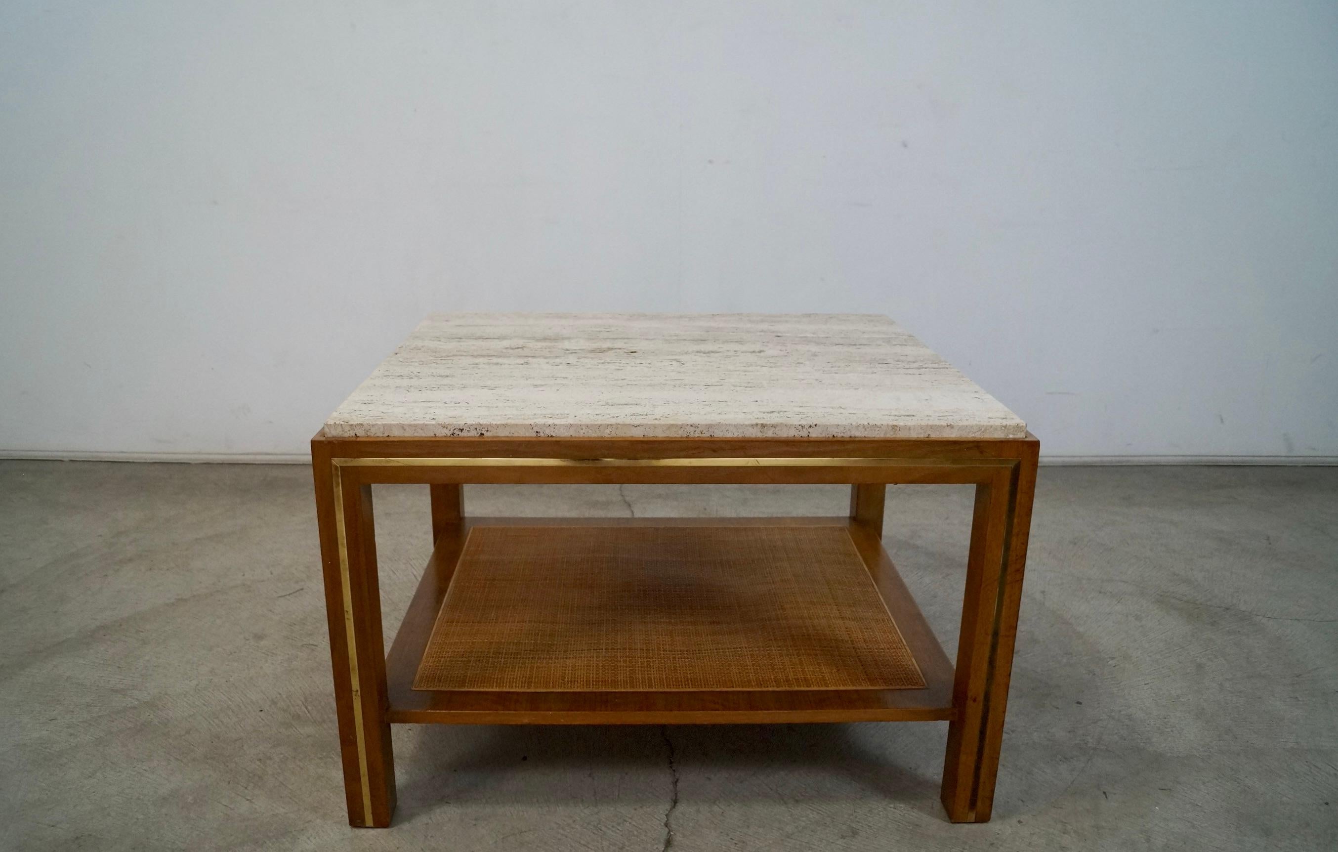 Vintage Mid-century Modern end table for sale. Very solid and well made. Has a travertine insert on the top, and a walnut frame with a brass inlaid in the walnut frame. It has a bottom shelf with caning. It's a beautiful accent table, and can work