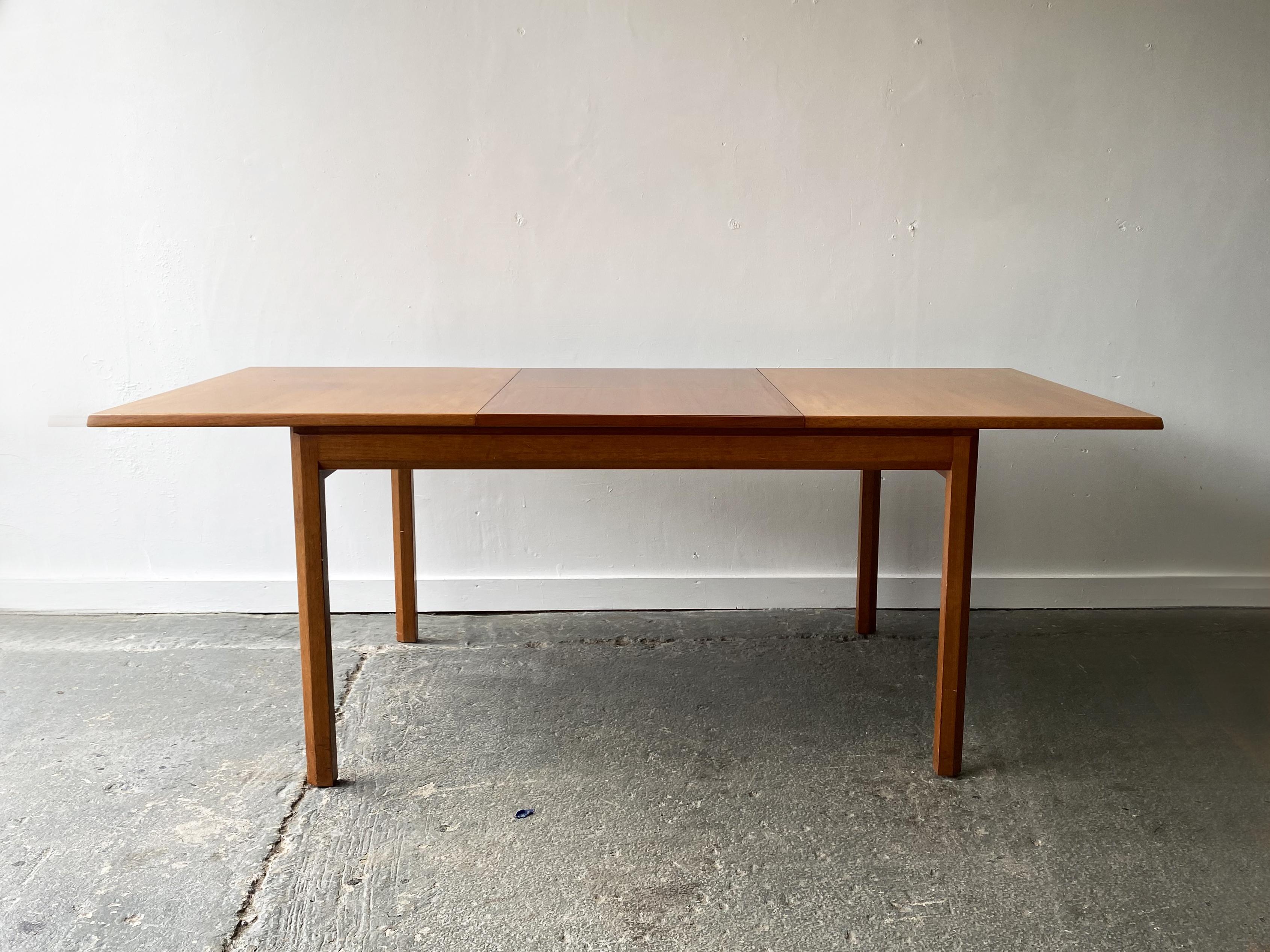 A Mid-Century teak extending dining table produced in the 1960’s by English manufacturer White & Newton. Very minimal linear design. Light warm toned teak throughout. 

Size 
Fully extended width 198cm
Unextended (closed) width 137cm
Depth