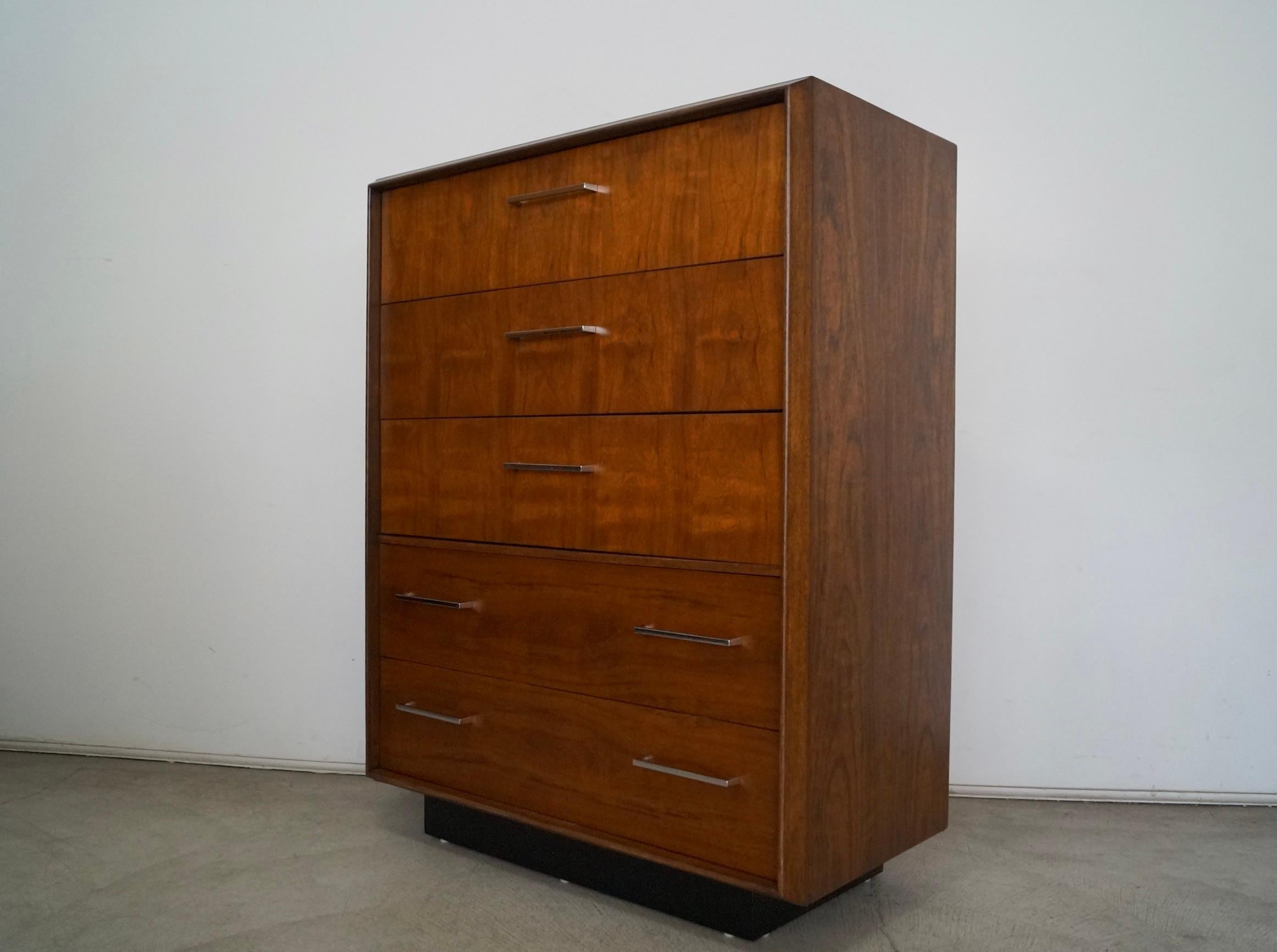 Vintage 1960s Mid-Century Modern dresser for sale. Manufactured by Lane, and has been professionally refinished. Has the original chrome handles, and has a plinth base in a black finish. It has five drawers that are dovetailed on both ends. It has