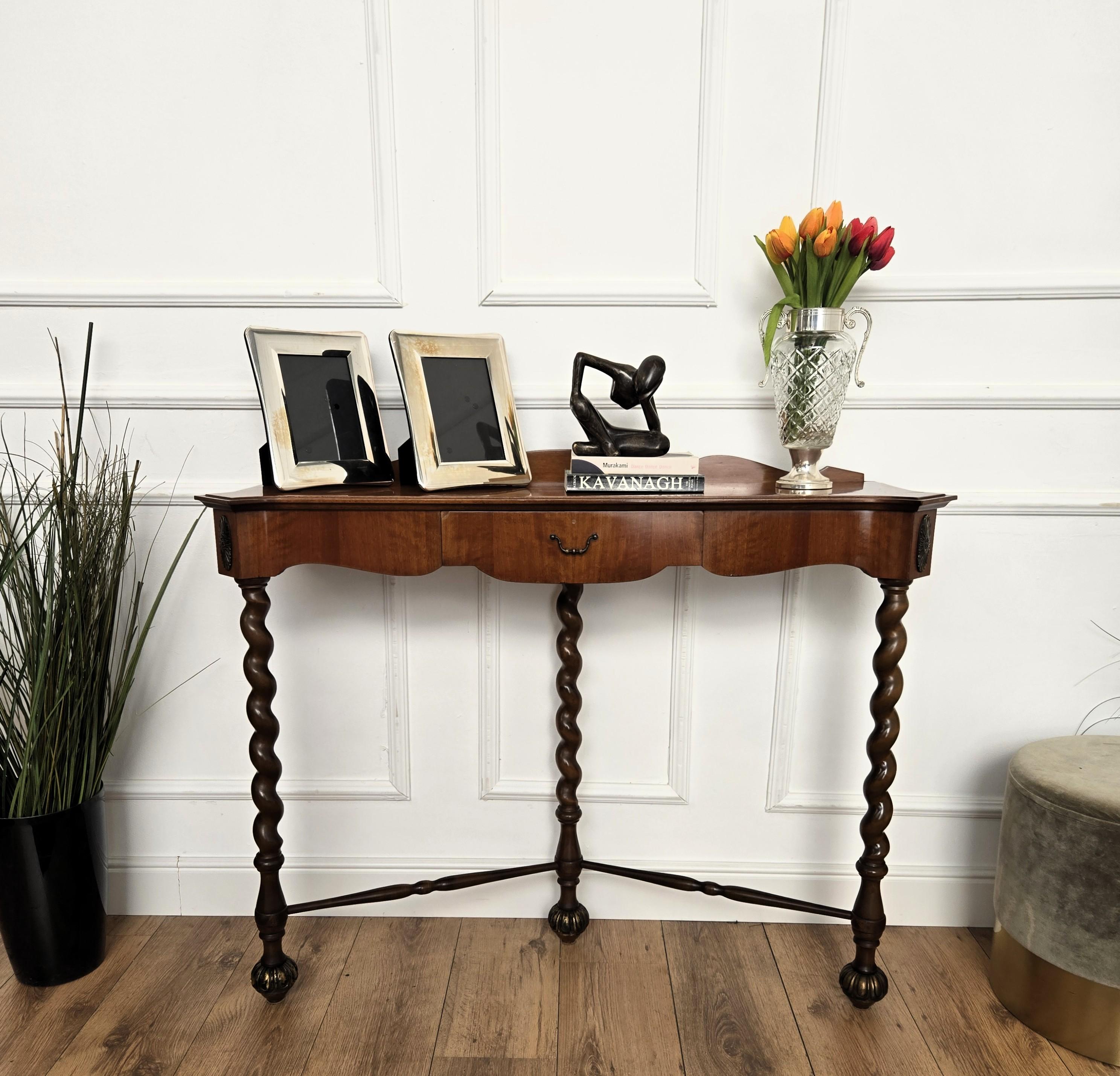 Very elegant and refined Italian 1960s Mid-Century Modern design console table highlighted by the 3 beautifully shaped barley twisted wooden legs with the central drawer. This piece is in perfect structural conditions, it is not meant as a