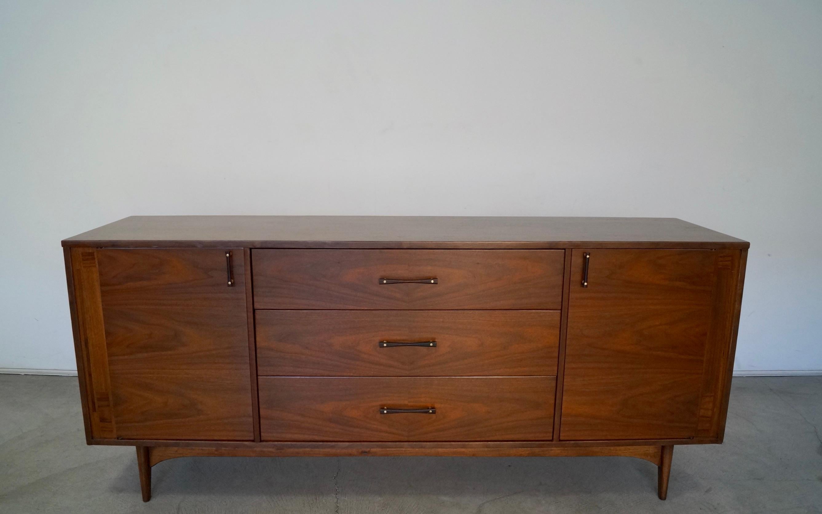 Vintage Mid-Century Modern credenza for sale. Manufactured in the 1960's by Kroehler, and has been professionally refinished. It's made of walnut and rosewood, and is a rare design by Kroehler. It has two credenza doors that open up to four drawers