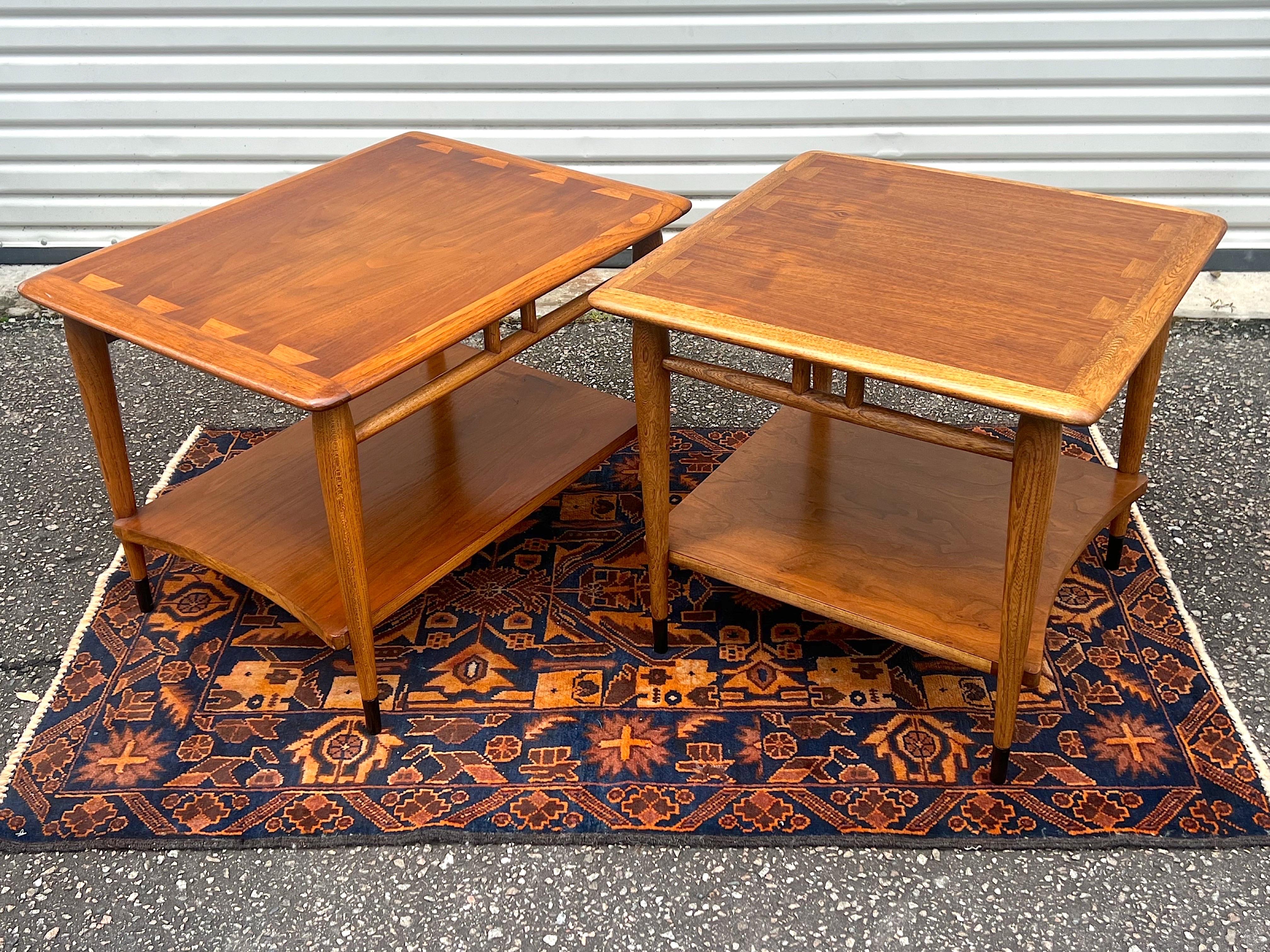 Iconic Mid-Century Modern end tables from the Lane “Acclaim” collection. The tables feature the signature large dovetail tops and curved lower shelf and black painted tips on the legs. 

The square table measures: 20.5” tall x 23” deep x 22.75