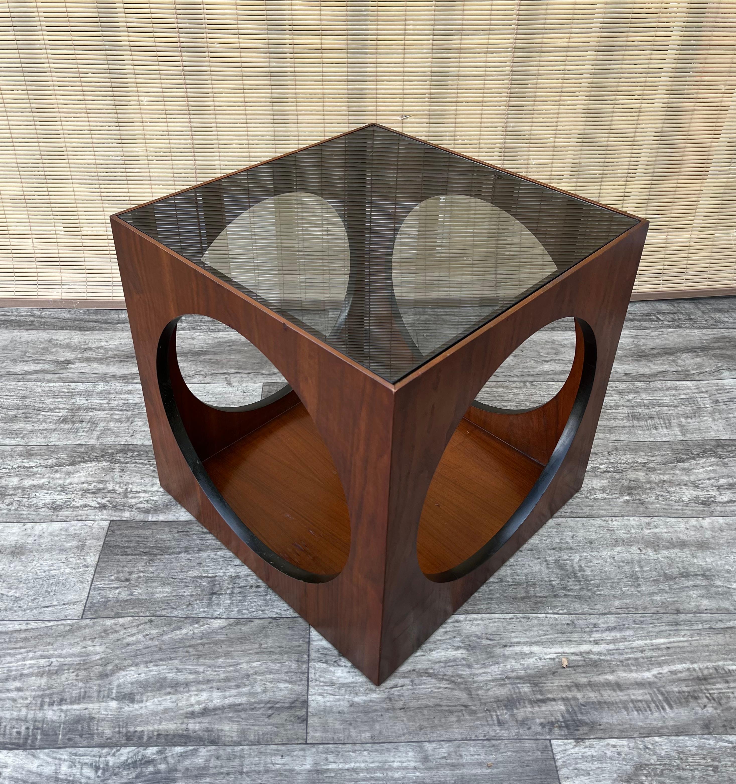 Vintage 1960s Mid-Century Modern Space Age Cube Side Table With Smoke Glass Top by Lane Altavista Furniture. 
Ce meuble présente un design moderne de l'ère spatiale, avec des découpes circulaires sur tous les côtés, un plateau amovible en verre fumé
