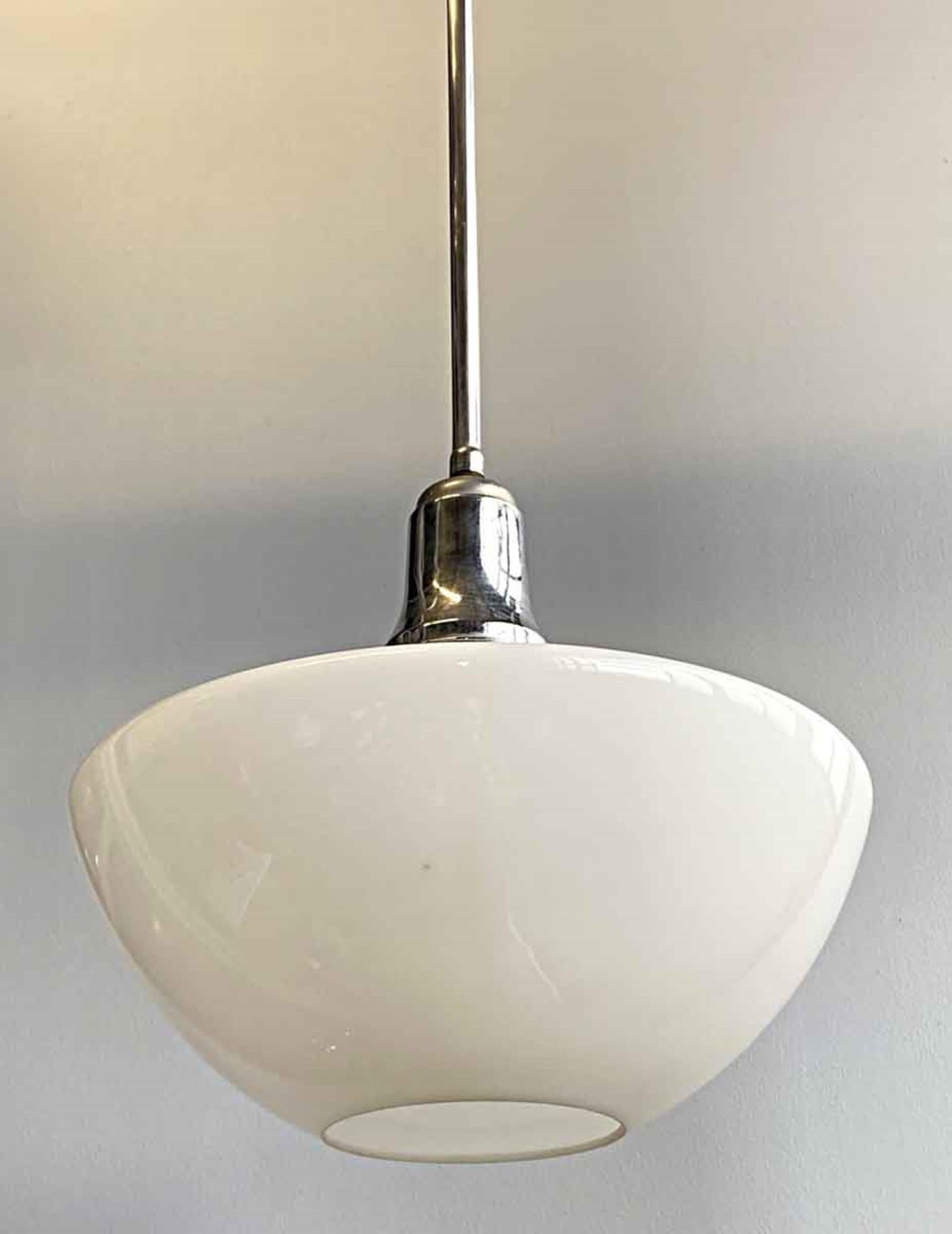1960s Mid-Century Modern white milk glass globe with rare down light shaped shade. This pendant light comes with the original nickel plated brass pole fitter. This can be seen at our 333 West 52nd St location in the Theater District West of