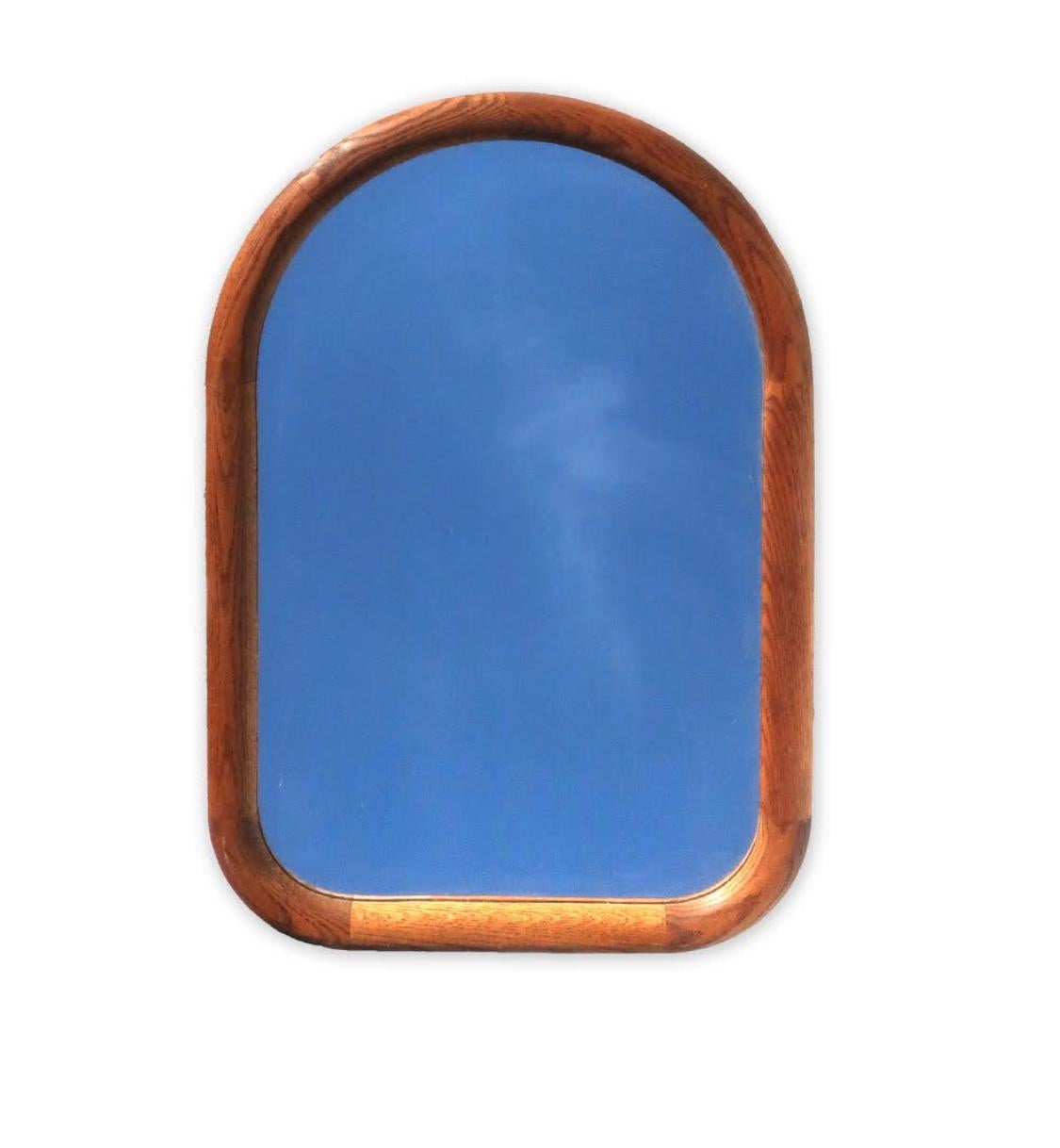 A handsome Mid-Century Modern wall mirror with an arched oak frame and clean lines that will match most any decor. 

Excellent vintage condition.

Measures: 20” x 31” x 1”.
    