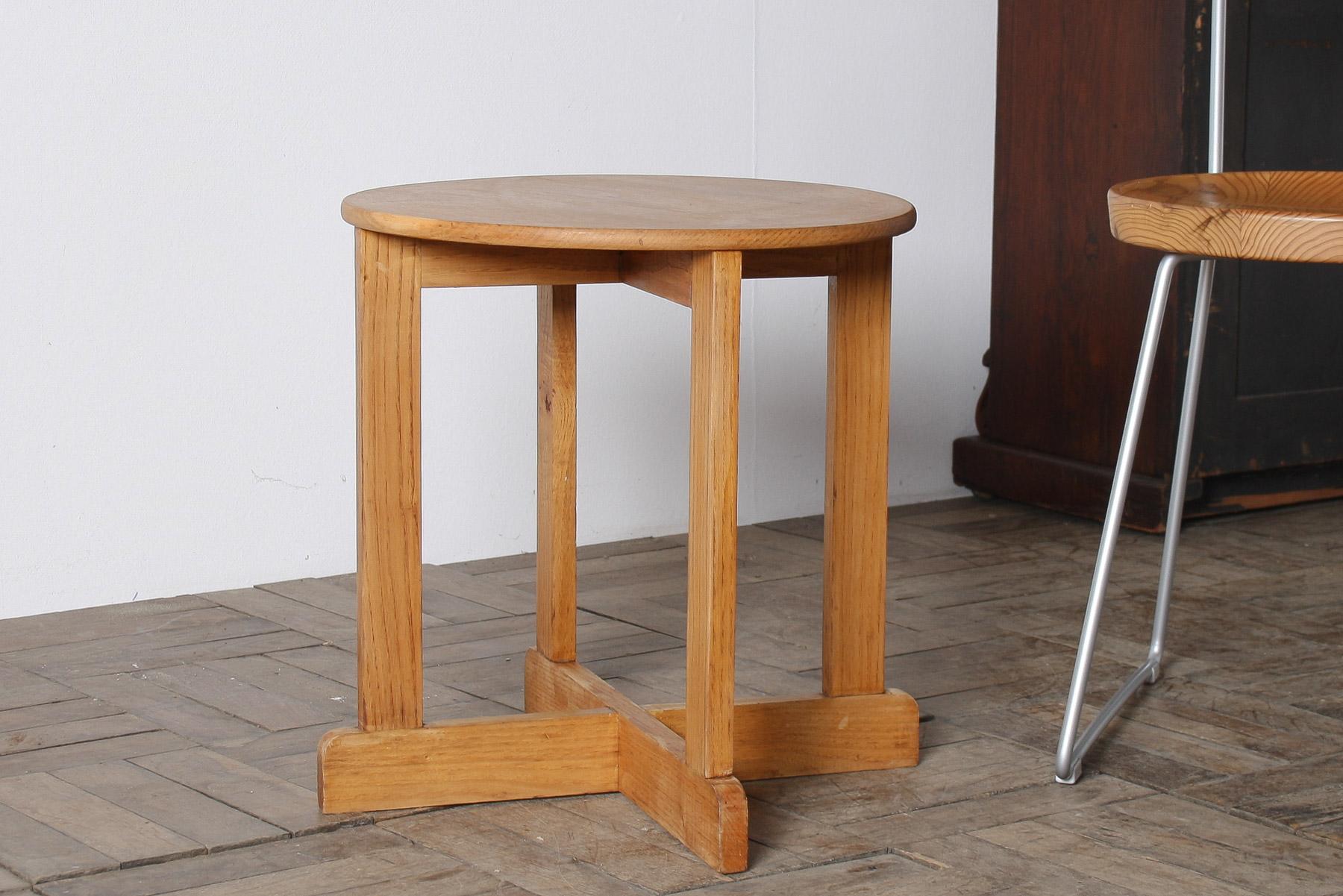 Voici une table d'appoint du milieu du siècle en frêne massif, un mélange parfait de simplicité moderniste et d'influences subtiles du mouvement Arts and Crafts. La pièce présente un simple plateau rond à une planche qui repose élégamment sur un