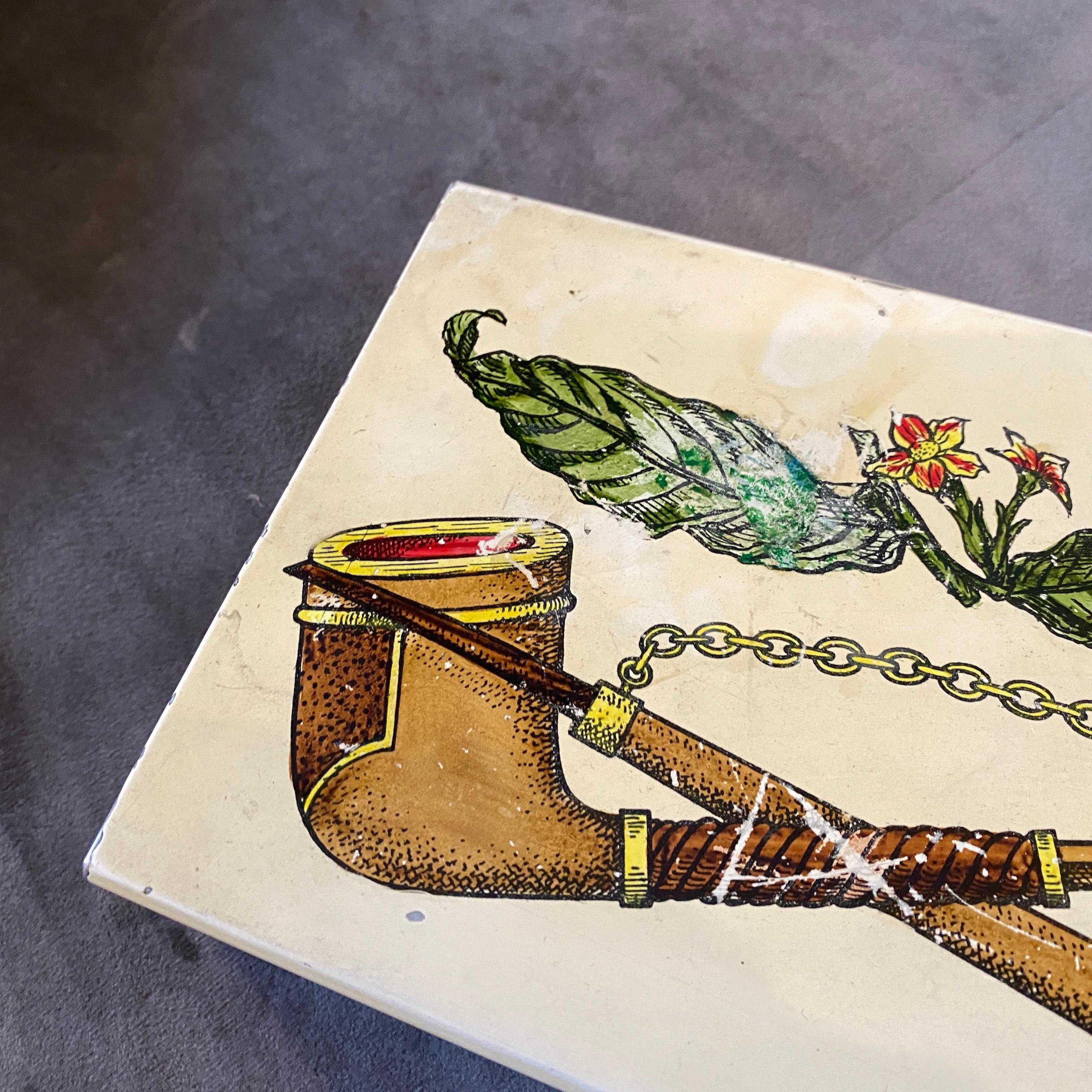 A stylish cigarette box decorated with pipes, made by Atelier Fornasetti, especially for Bucciarelli Milano department store. Mahogany and enameled metal have signs of the age. It can be used as playing card or a jewelry box.