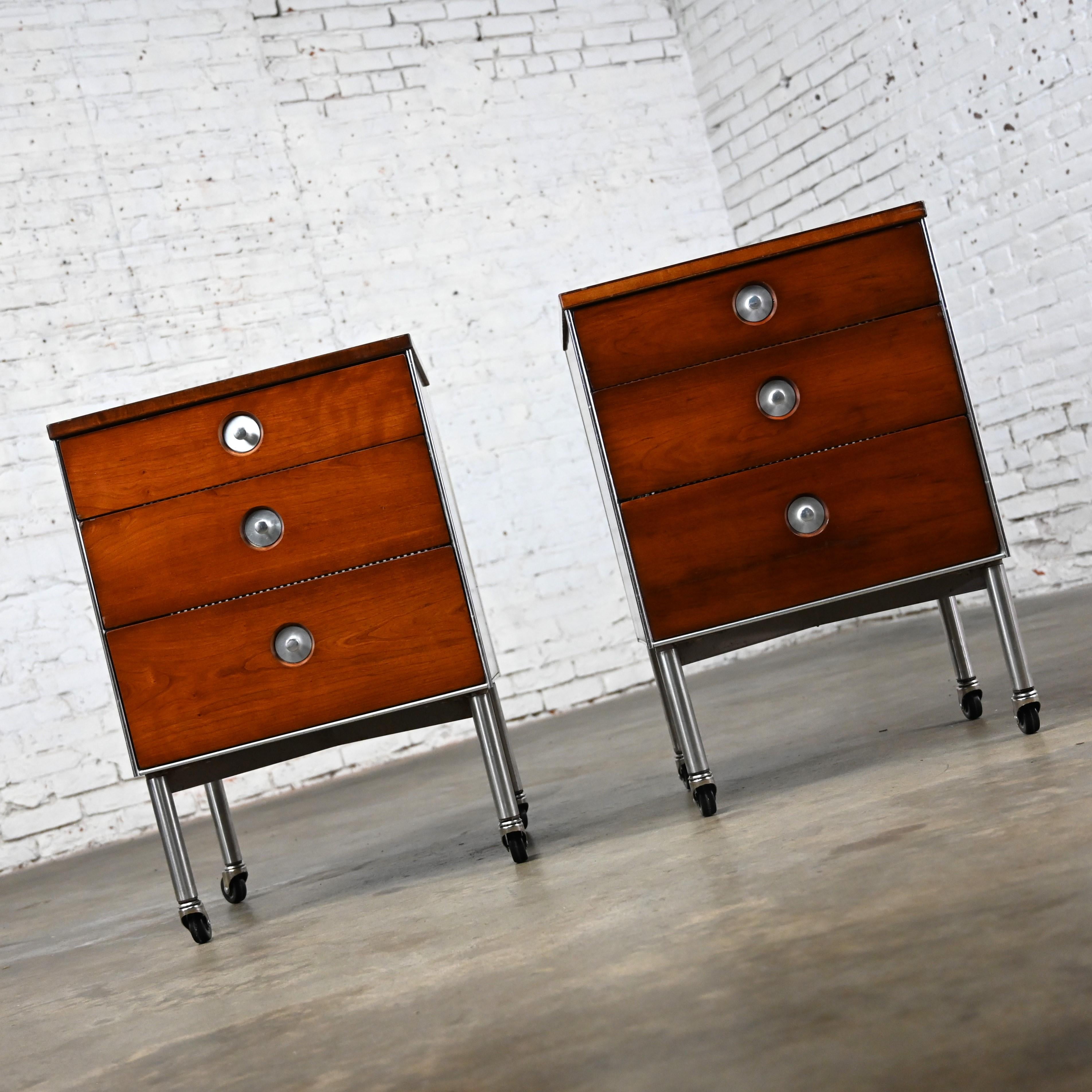 Marvelous vintage Mid-Century Modern Raymond Loewy for Hill Rom nightstands, end tables, or cabinets on casters, a pair. Comprised of aluminum frames, walnut veneer sides and door fronts, aluminum pulls & trim, gray & white linen look laminate tops,
