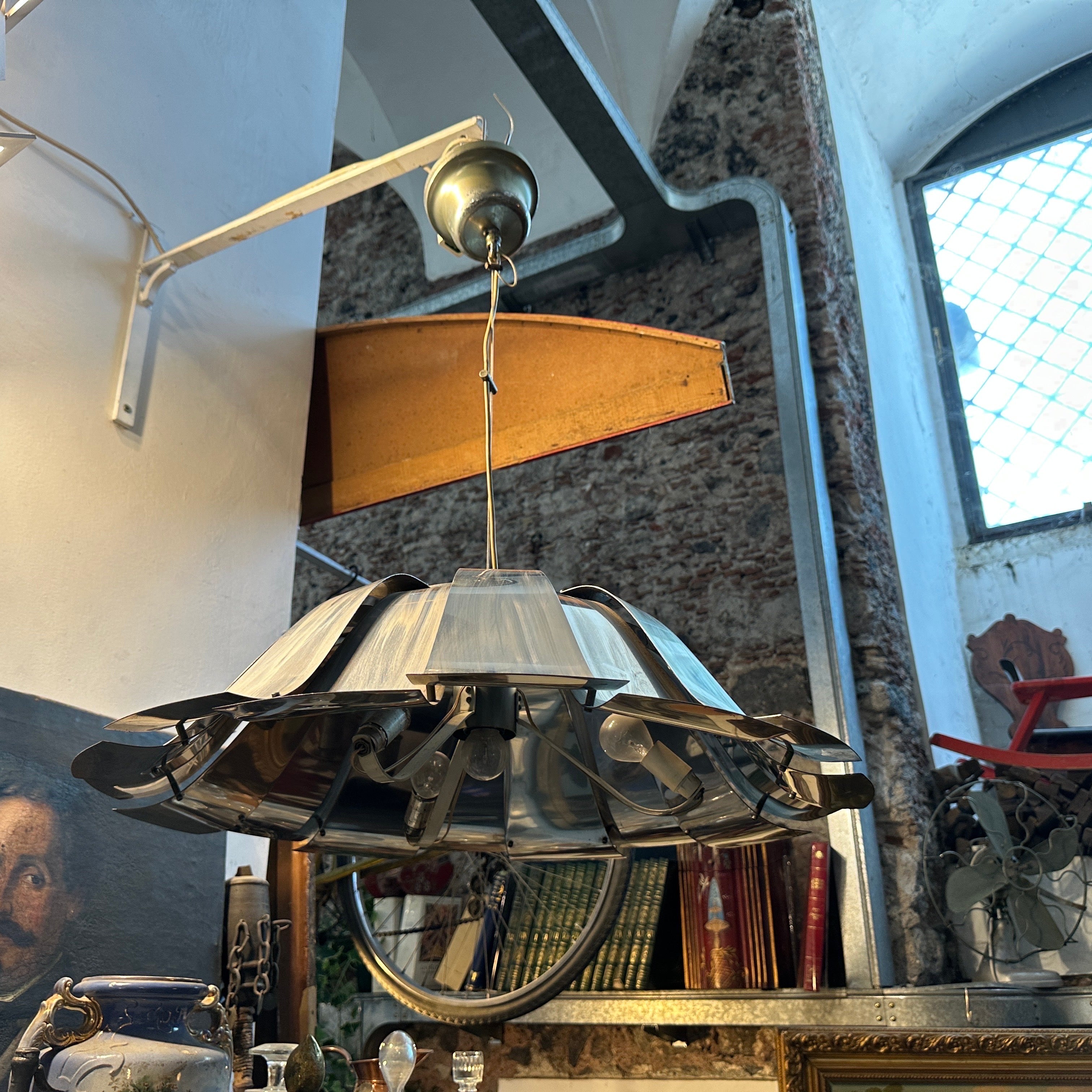 Lampada a sospensione in acciaio italiana della metà del secolo scorso attribuita a Reggiani
Porta l'iconico design italiano nel tuo spazio con questa scultorea lampada a sospensione Mid-Century Modern degli anni '60, attribuita al rinomato