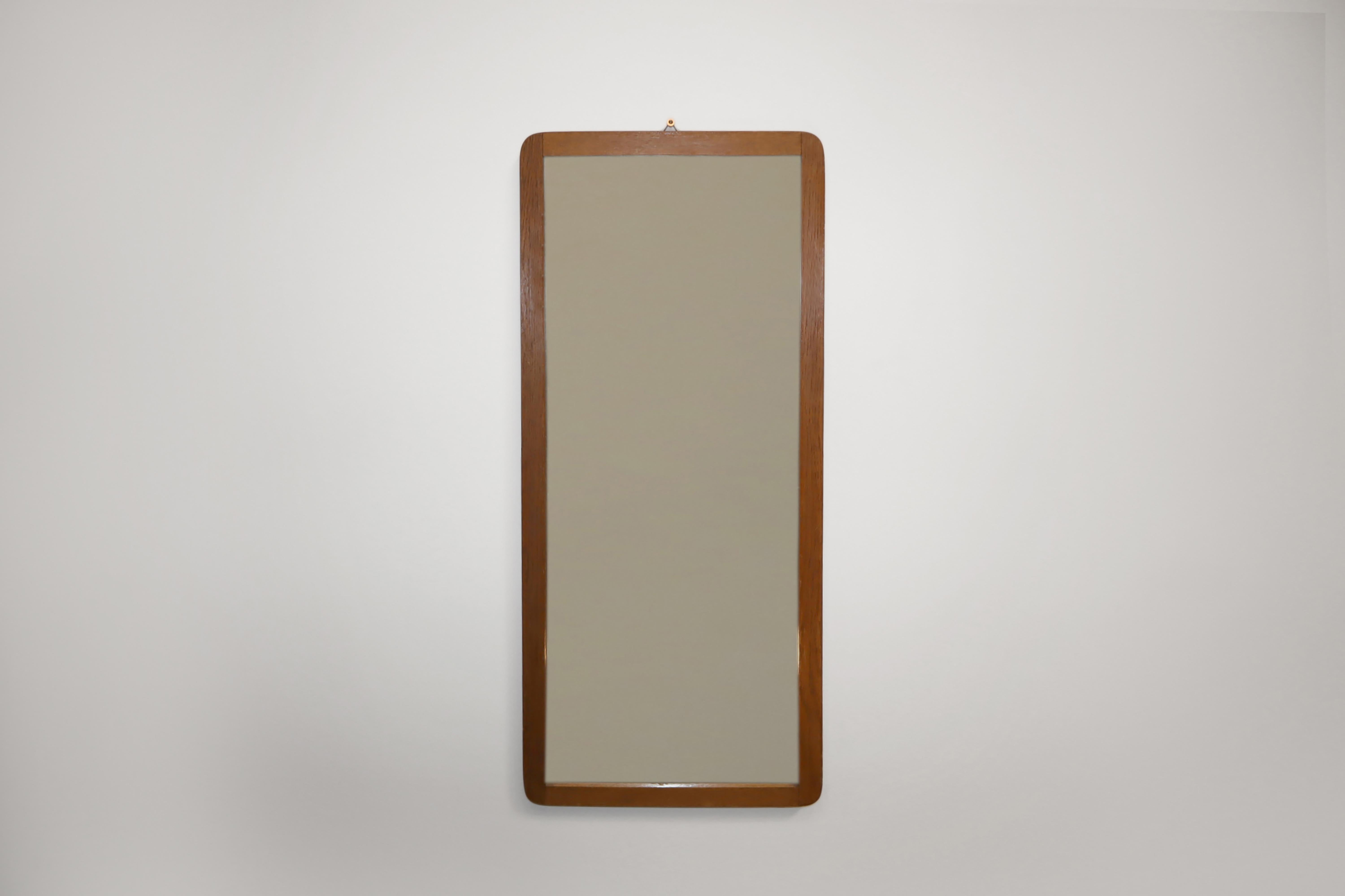 Mid-Century Modern Scandinavian wall hanging mirror in hardwood, probably teak. Made in Denmark in 1960s.

This mirror is constructed in wood. It is rectangular in shape with rounded corners and attractive mortice and tenon joints, which get