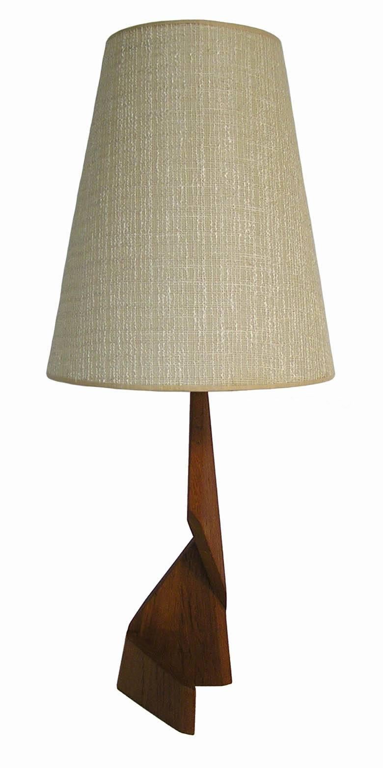 A uniquely designed Zig Zag teak table lamp from the 1960s Danish Mid-Century Modern era. Amazing craftsmanship throughout featuring a sculpted geometrical solid teak base with original conical shade and three-way light socket. Lamp has been