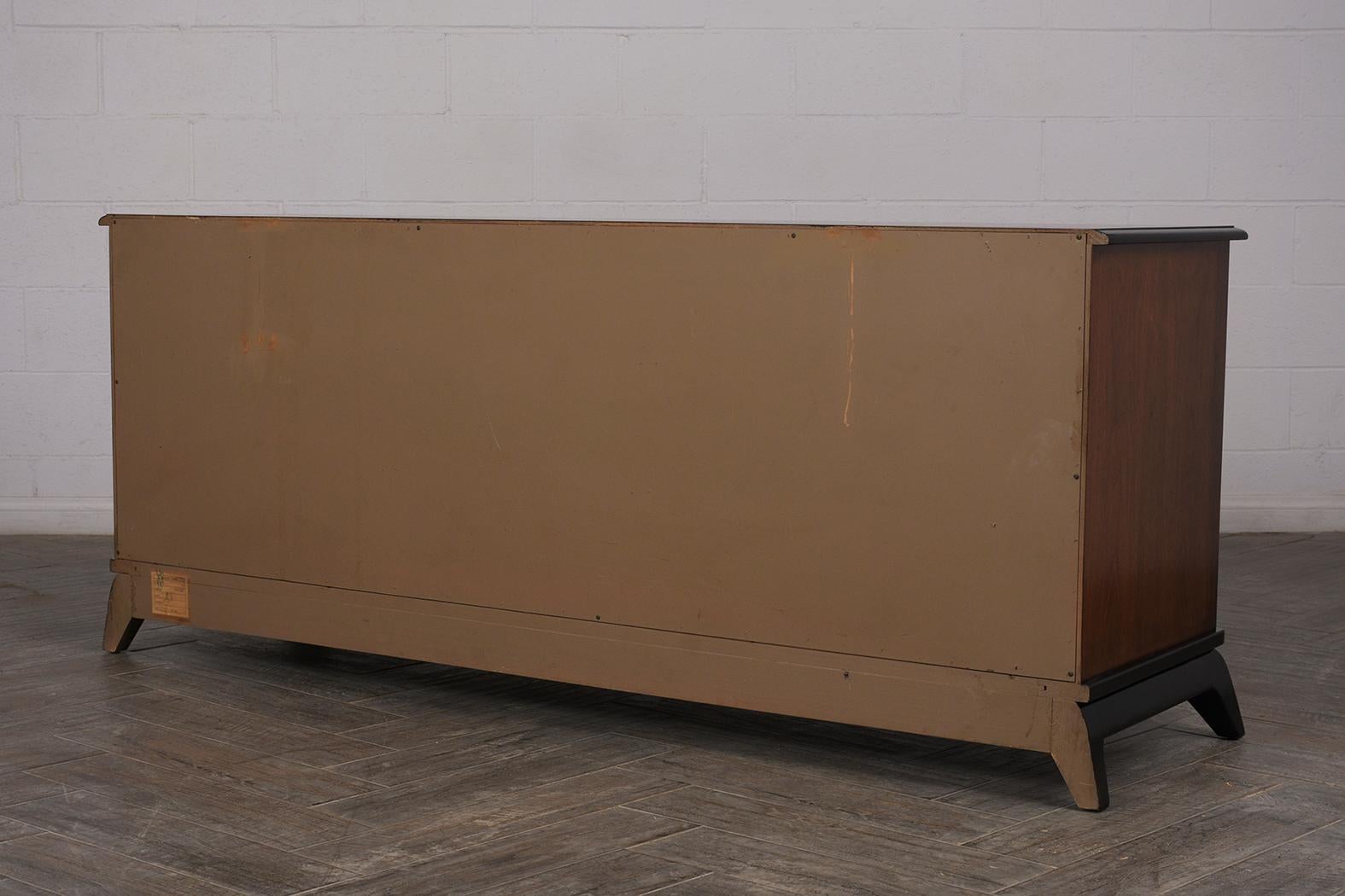 A 1960s Mid-Century Modern lacquered sideboard painted in a black and brown finish. The sideboard has useful drawers and doors for proper storage.