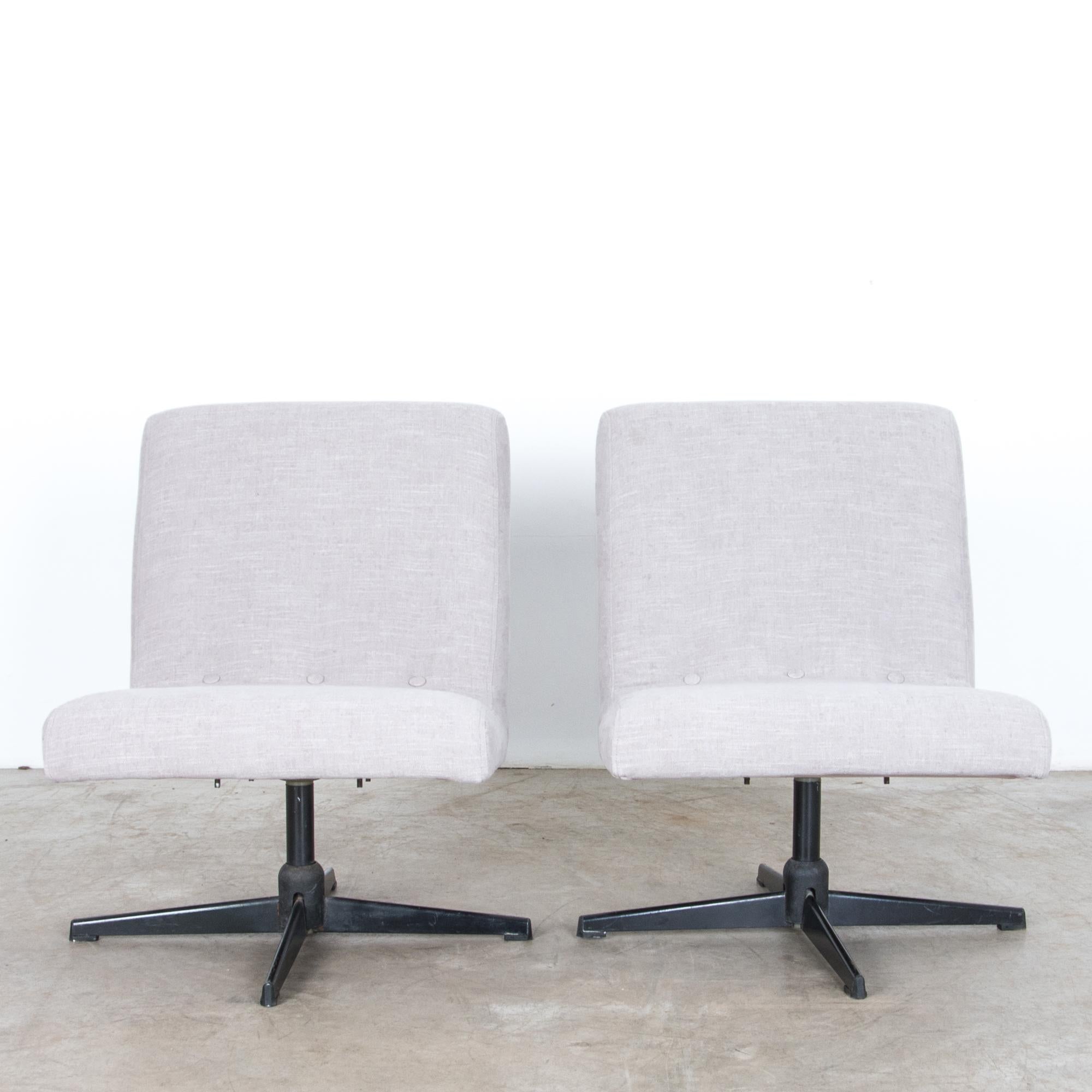 A pair of rotating metal chairs from Czech Republic, circa 1960. Re-dressed in a chic textured cool grey, this midcentury design looks fresh sporting distinctive geometric shape, with a subtle angle. Reclined for comfort, this sleek design elegantly