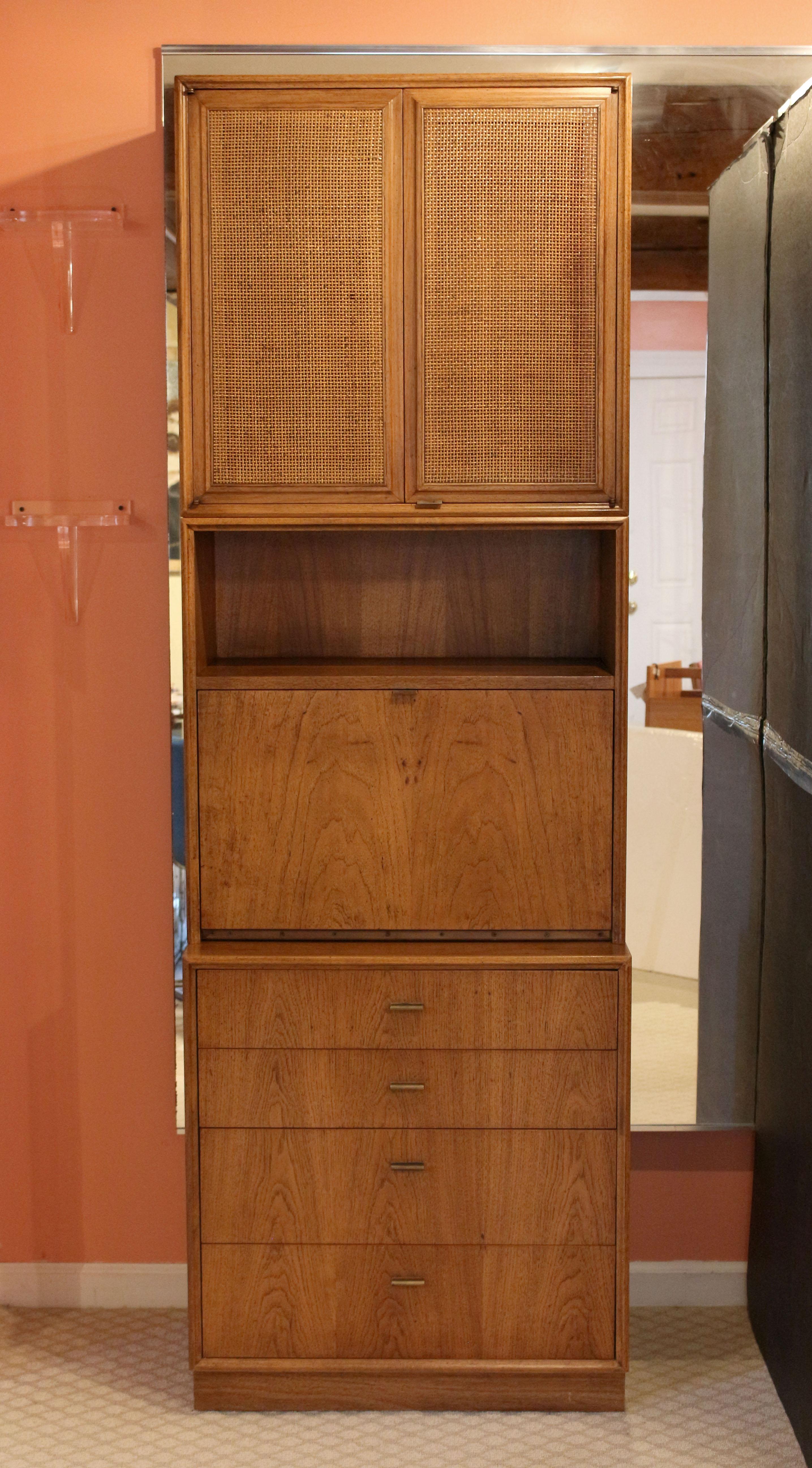 A significant quality 1960's mid-century modern three part Founders in solid pecan. Designed by Jack Cartwright. The cabinet with woven cane panels rests on a display/bookcase section with drop-front writing or bar surface. Below are four drawers