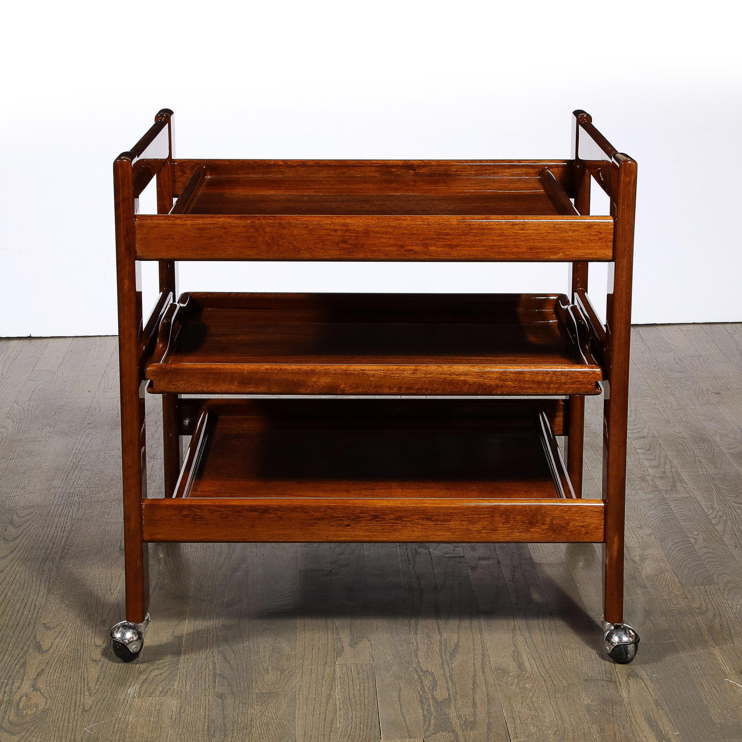 This stunning Mid-Century Modern bar cart was realized in the United States circa 1960. Sitting on aluminum castors, it features a rectilinear form consisting of two right angled hard geometric u-form sides structurally reinforced by side and end