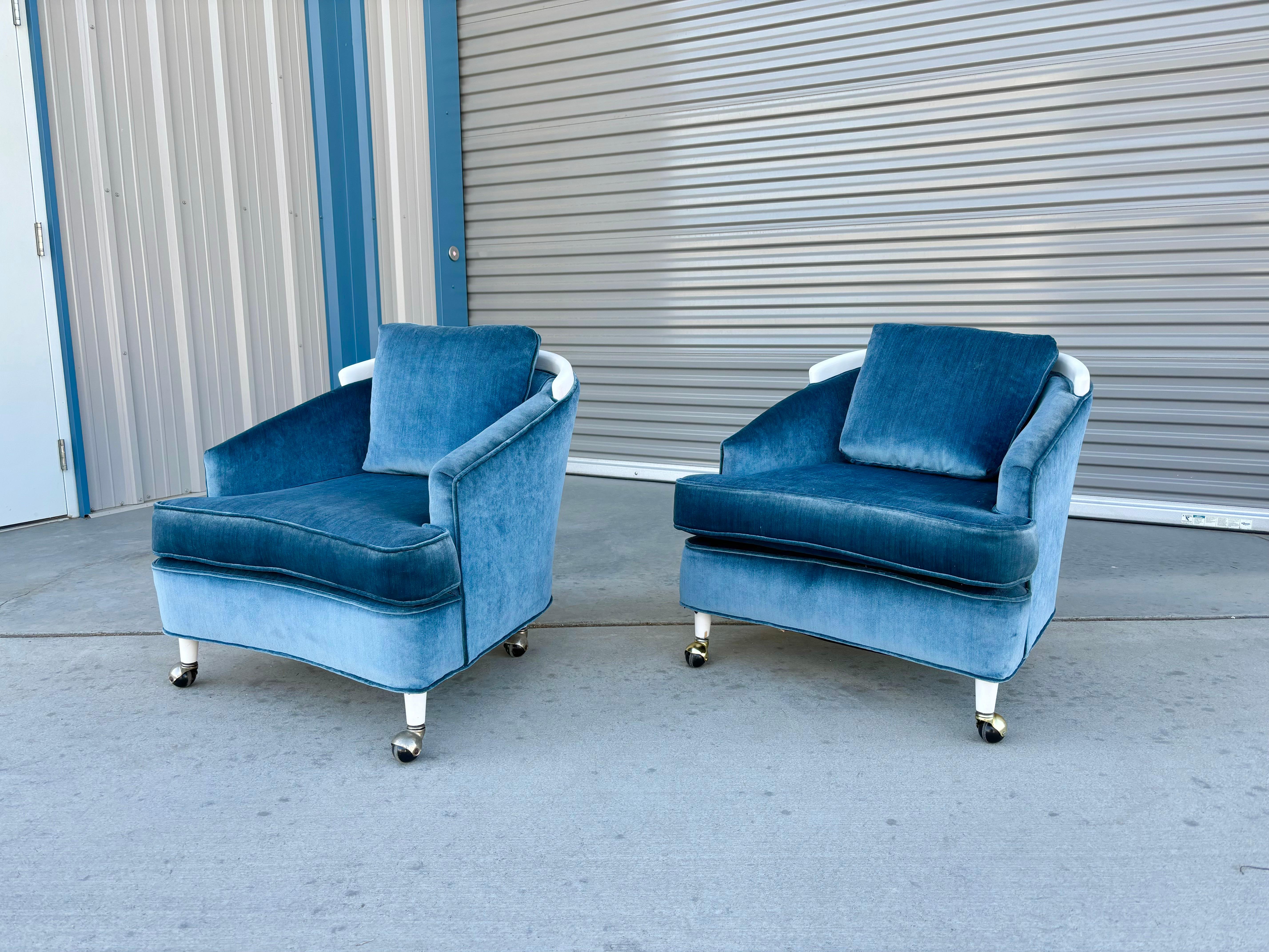 Mid-century velvet lounge chairs designed and manufactured in the United States circa 1960s. The chairs feature a newly blue velvet upholstery that is both comfortable and visually stunning. What sets these chairs apart is the elegant white curved
