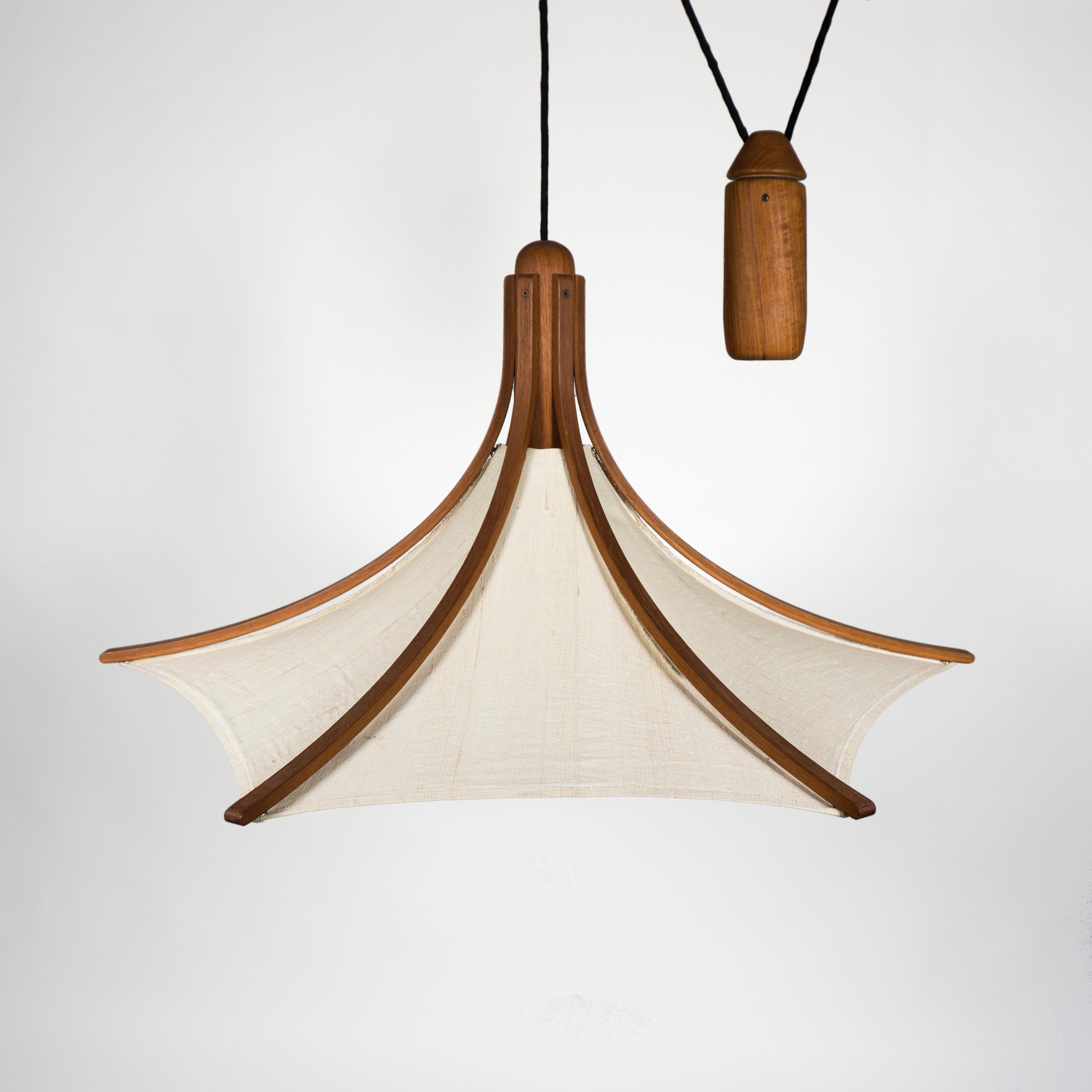 Stunning and large vintage teak pendant lamp with counterweight from Domus, type 2415.
The height-adjustable lamp is made of solid teak and the linen shade is removable and can be washed if necessary.
Stunning, elegant mid-century design with