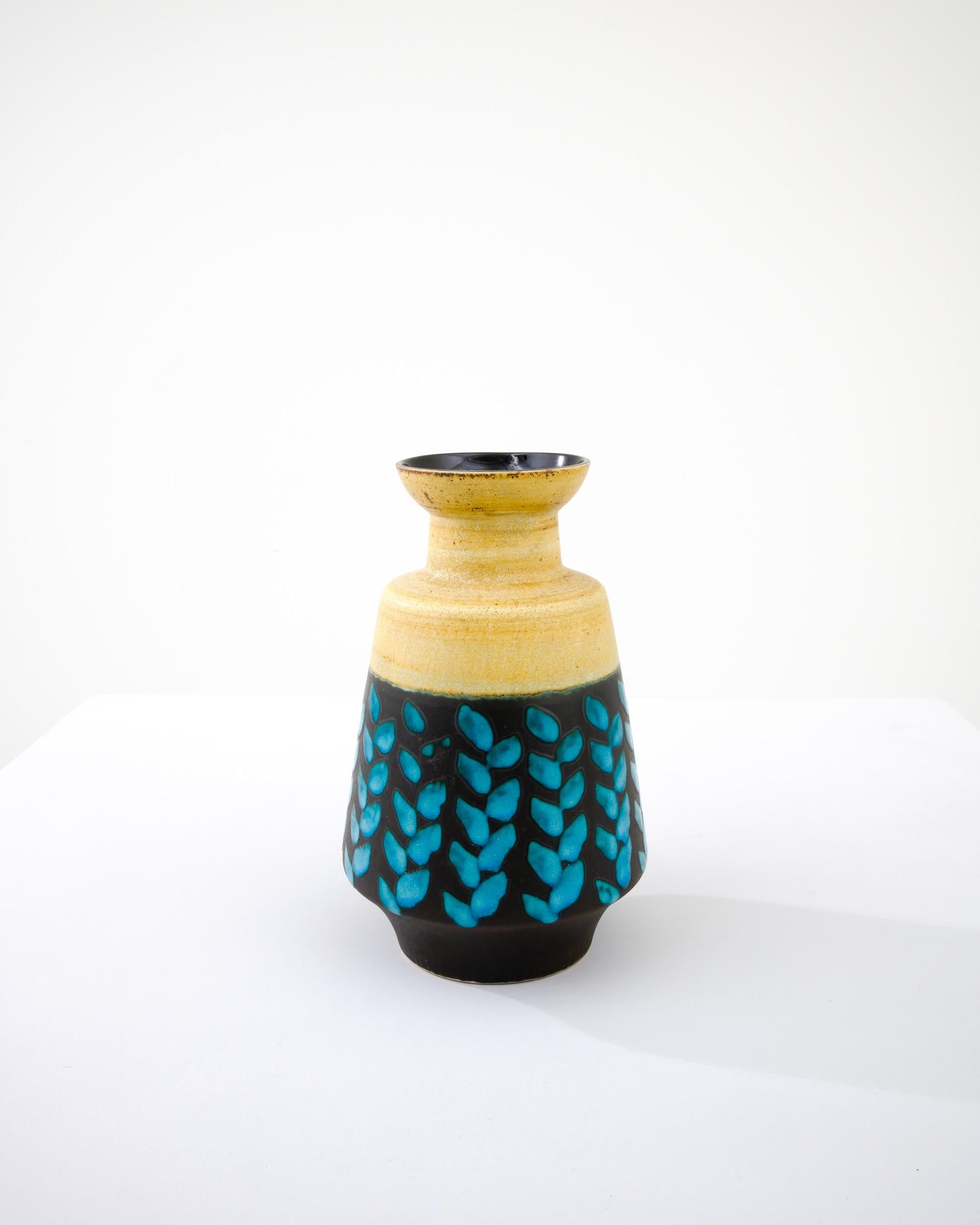 A ceramic vase from mid-20th century Germany. Neither large nor small, this studio made pot reflects the hand-held, and the handmade; the tactility of process and the artist's vision– realized on the potter’s wheel. Vibrant colors wrap the minimal