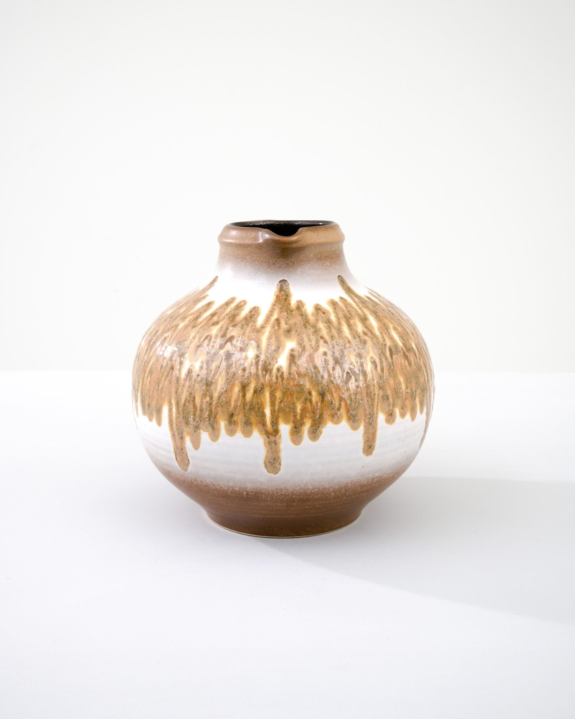 A ceramic vase from mid-20th century Germany. Neither large nor small, this studio made pot reflects the hand-held, and the handmade; the tactility of process and the artist's vision– realized on the potter’s wheel. A palette of ochres and umbres