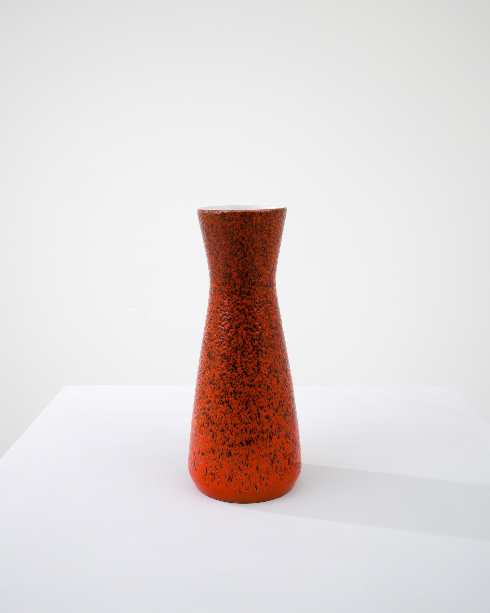 A ceramic vase from mid-20th century Germany. Neither large nor small, this studio made pot reflects the hand-held, and the handmade; the tactility of process and the artist's vision– realized on the potter’s wheel. Striking red and the minimal form