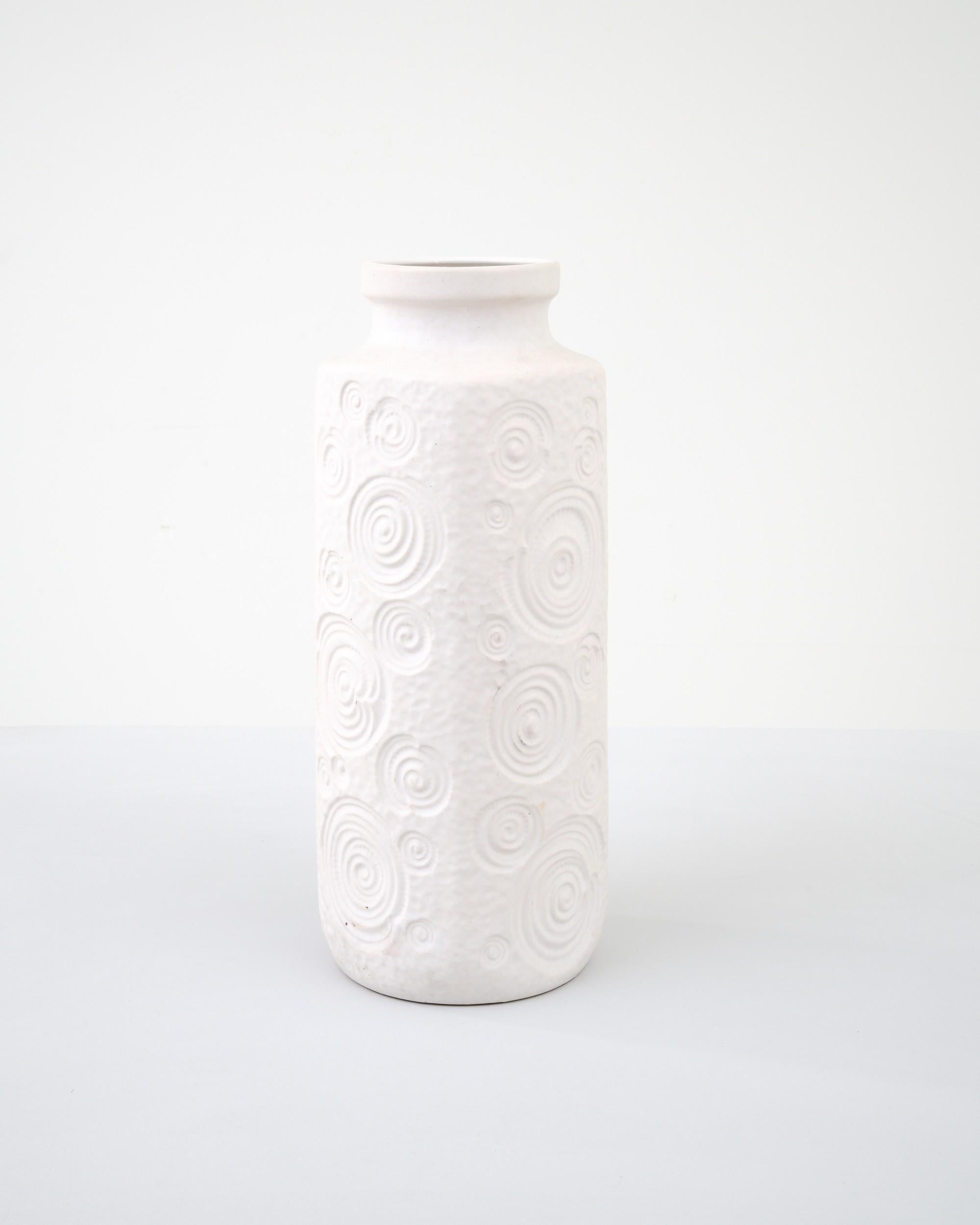 A ceramic vase from mid-20th century Germany. Neither large nor small, this studio made pot reflects the hand-held, and the handmade; the tactility of process and the artist's vision– realized on the potter’s wheel. Patterned white adorns the