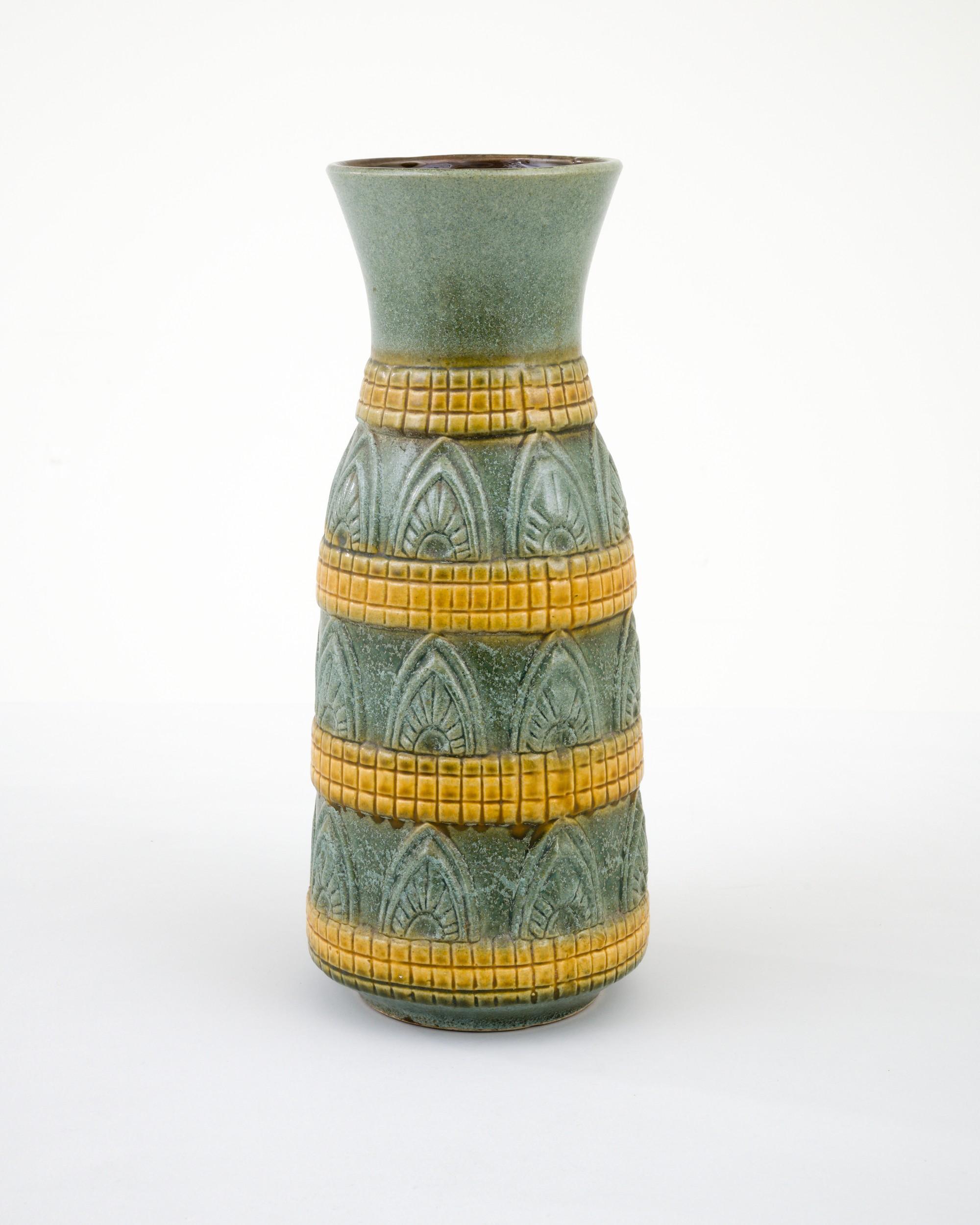 A ceramic vase from mid-20th century Germany. Neither large nor small, this studio made pot reflects the hand-held, and the handmade; the tactility of process and the artist's vision– realized on the potter’s wheel. Attractive olive green and yellow