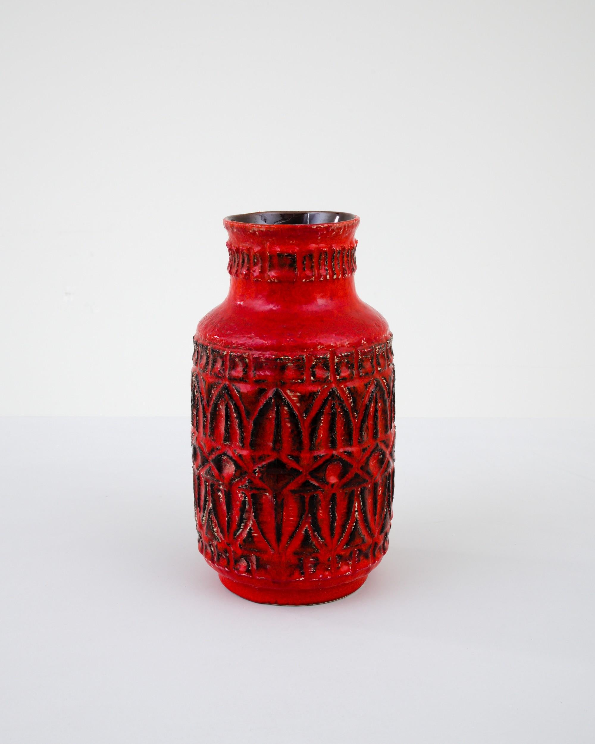 A ceramic vase from mid-20th century Germany. Neither large nor small, this studio made pot reflects the hand-held, and the handmade; the tactility of process and the artist's vision– realized on the potter’s wheel. Patterned red adorns a minimal