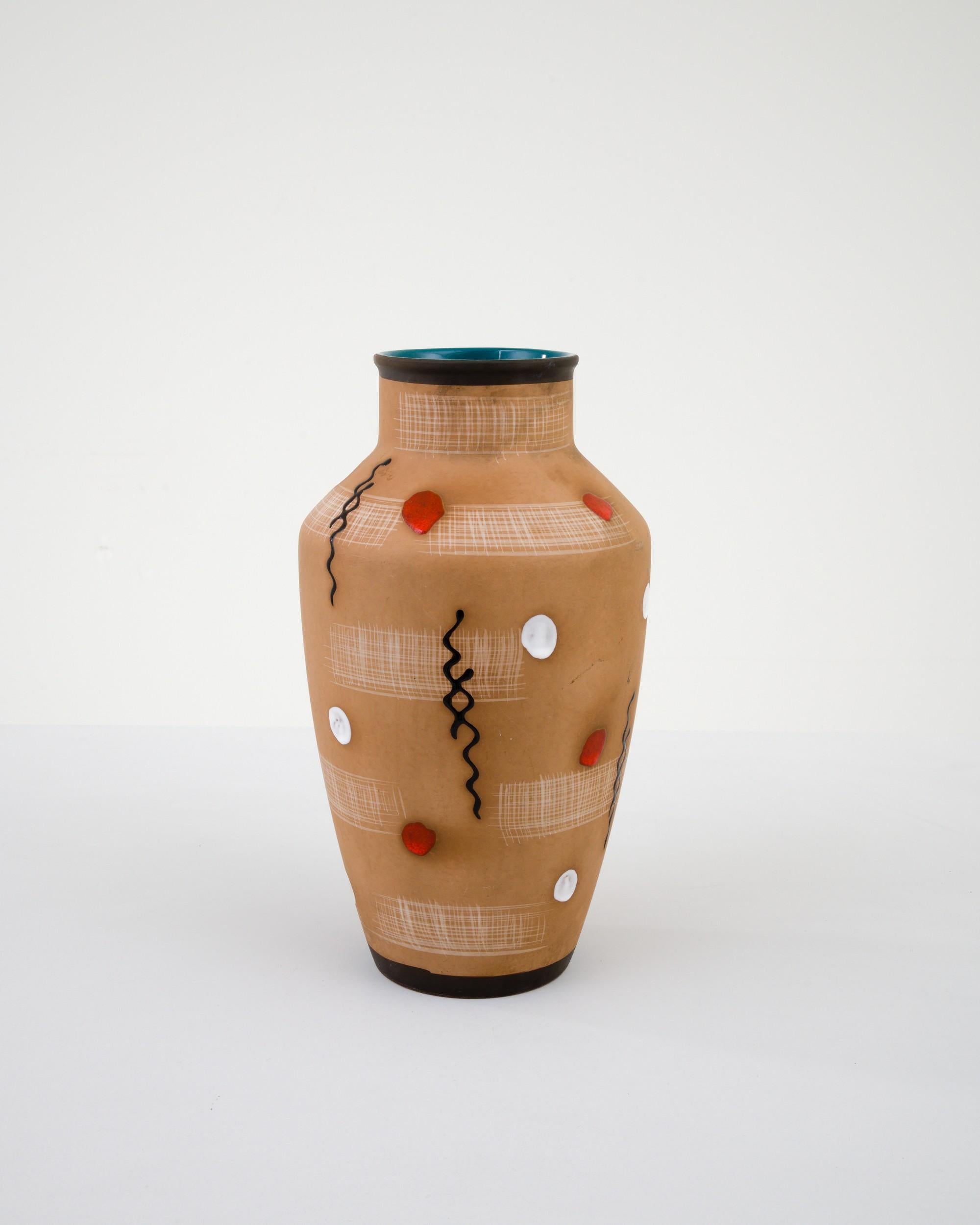 A ceramic vase from mid-20th century Germany. Neither large nor small, this studio made pot reflects the hand-held, and the handmade; the tactility of process and the artist's vision– realized on the potter’s wheel. Abstract geometry adorns a