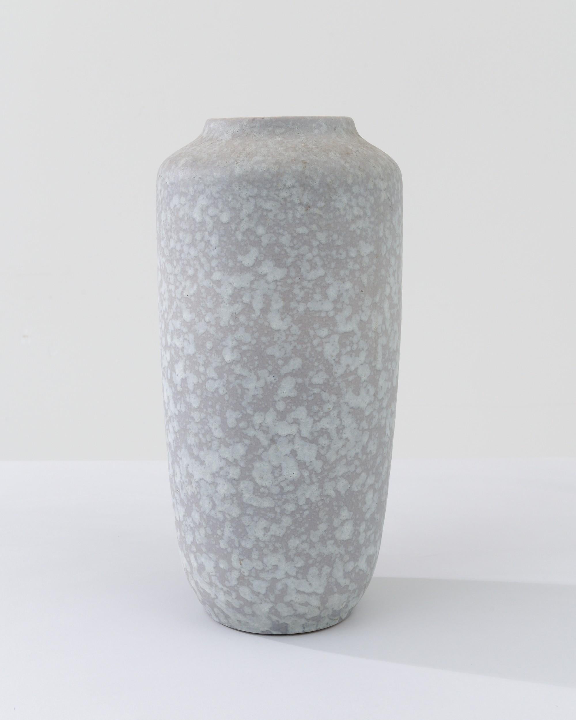 A ceramic vase from mid-20th century Germany. Neither large nor small, this studio made pot reflects the hand-held, and the handmade; the tactility of process and the artist's vision– realized on the potter’s wheel. Cool colored neutrals intermingle
