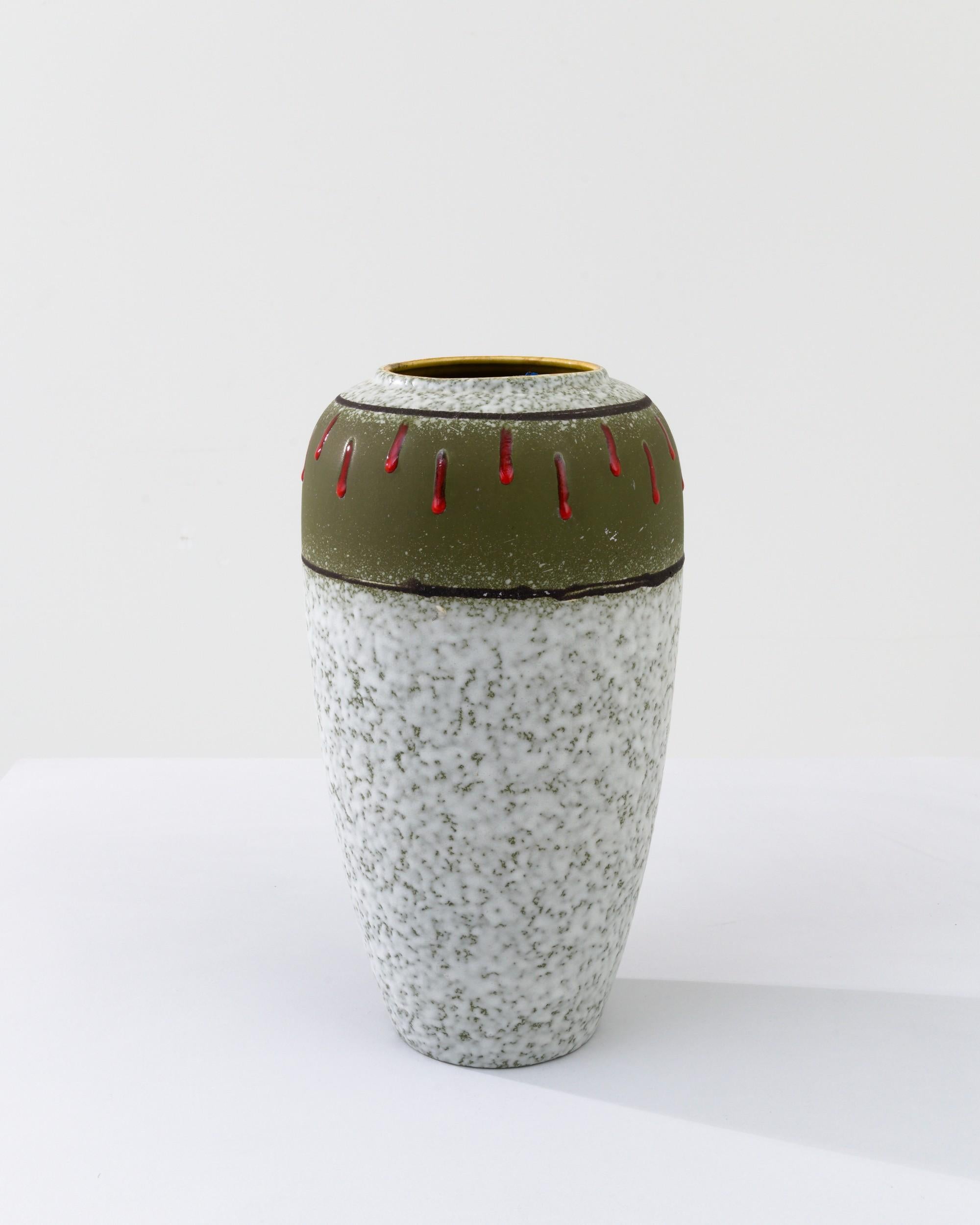 A ceramic vase from mid-20th century Germany. Neither large nor small, this studio made pot reflects the hand-held, and the handmade; the tactility of process and the artist's vision– realized on the potter’s wheel. Layered tones create a unique
