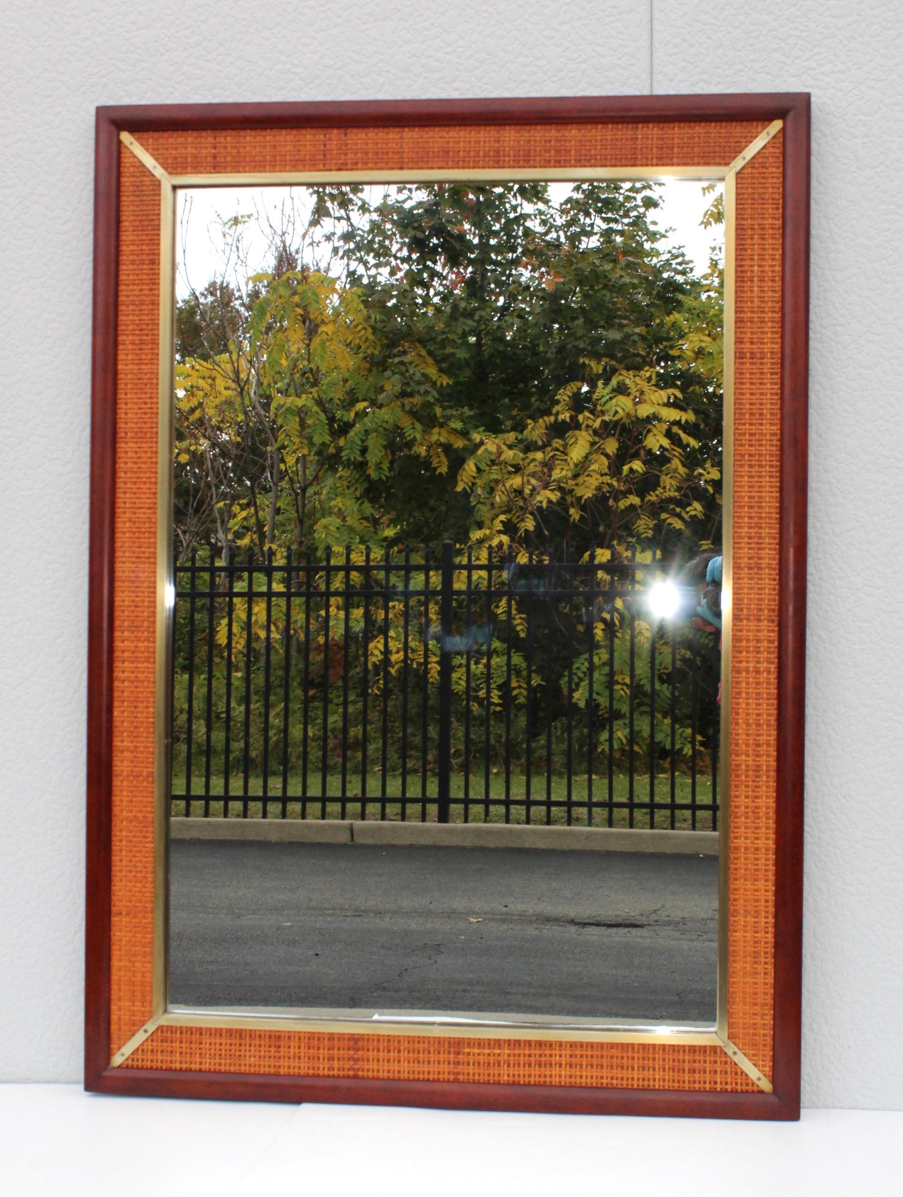 Stunning 1960s Mid-Century Modern well made solid walnut and rattan with brass detail mirror by Grosfeld design attributed to Marc Berge. In vintage original condition with minor wear and some patina to the brass.