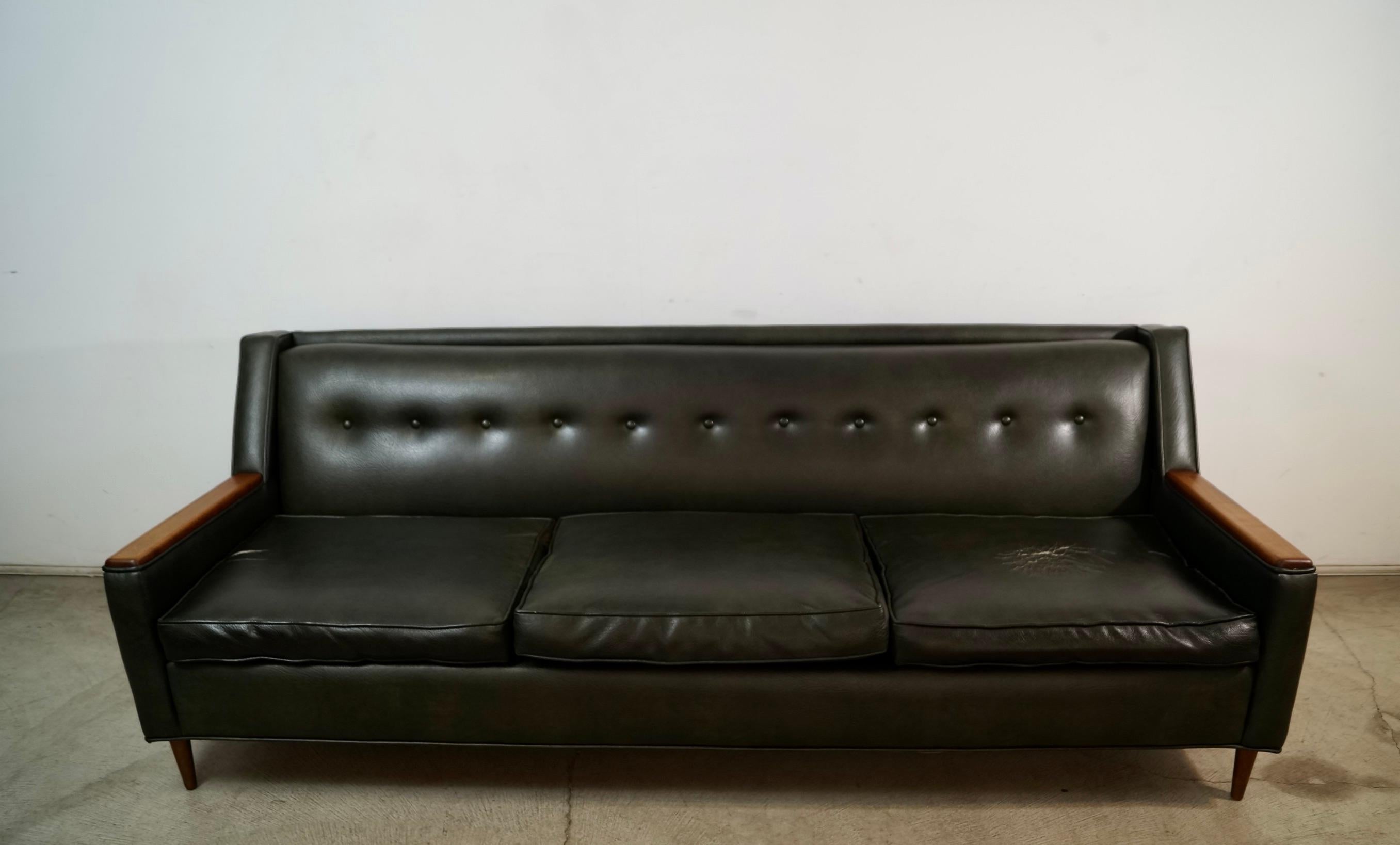 Original vintage Midcentury Modern couch for sale. In the manner of Adrian Pearsall. Was previously reupholstered in a dark green almost black vinyl. The frame and exterior are in excellent condition. Two of the cushions have wear on them as shown.