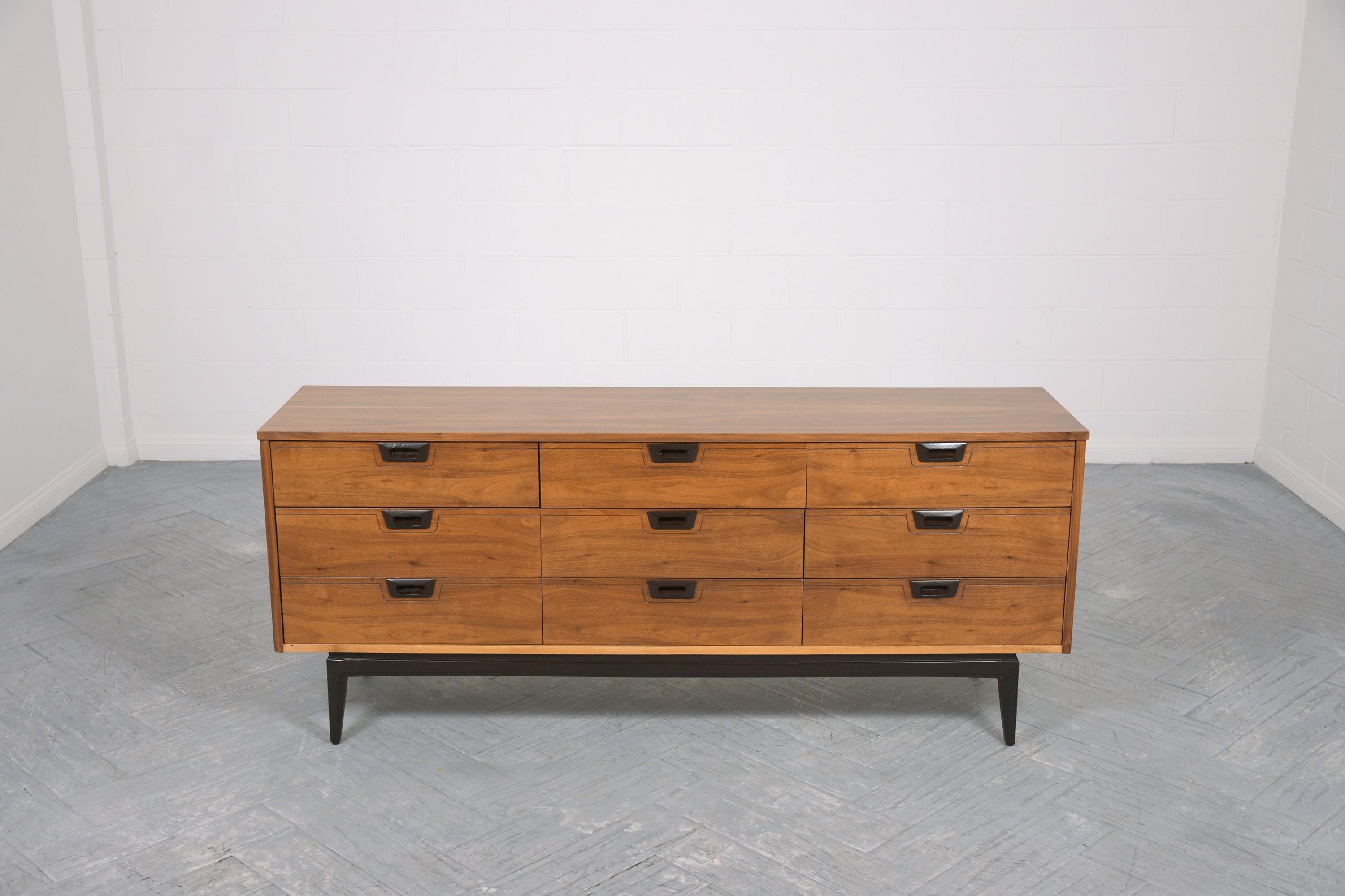 An extraordinary 1960s Mid-Century Modern walnut credenza in great condition is hand-crafted out of walnut wood and has been newly restored by our professional craftsmen team. This vintage dresser has a sleek design and is newly refinished in walnut