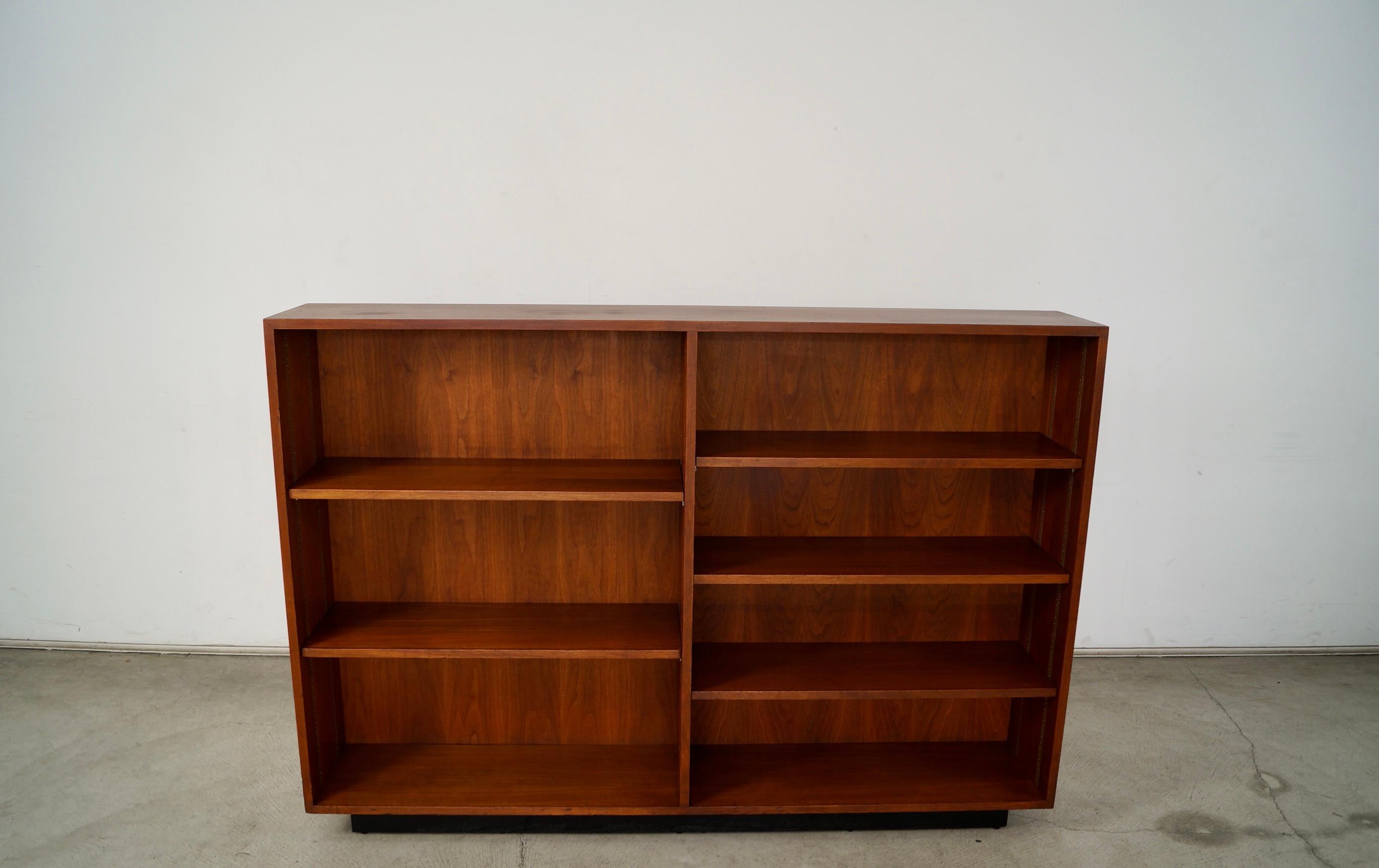 Scaffale originale Midcentury Modern in vendita. Ha cinque ripiani regolabili e due ripiani inferiori. È realizzato in noce con una base a zoccolo in finitura ebano più scura. È davvero solido e ben fatto e presenta delle bellissime venature di