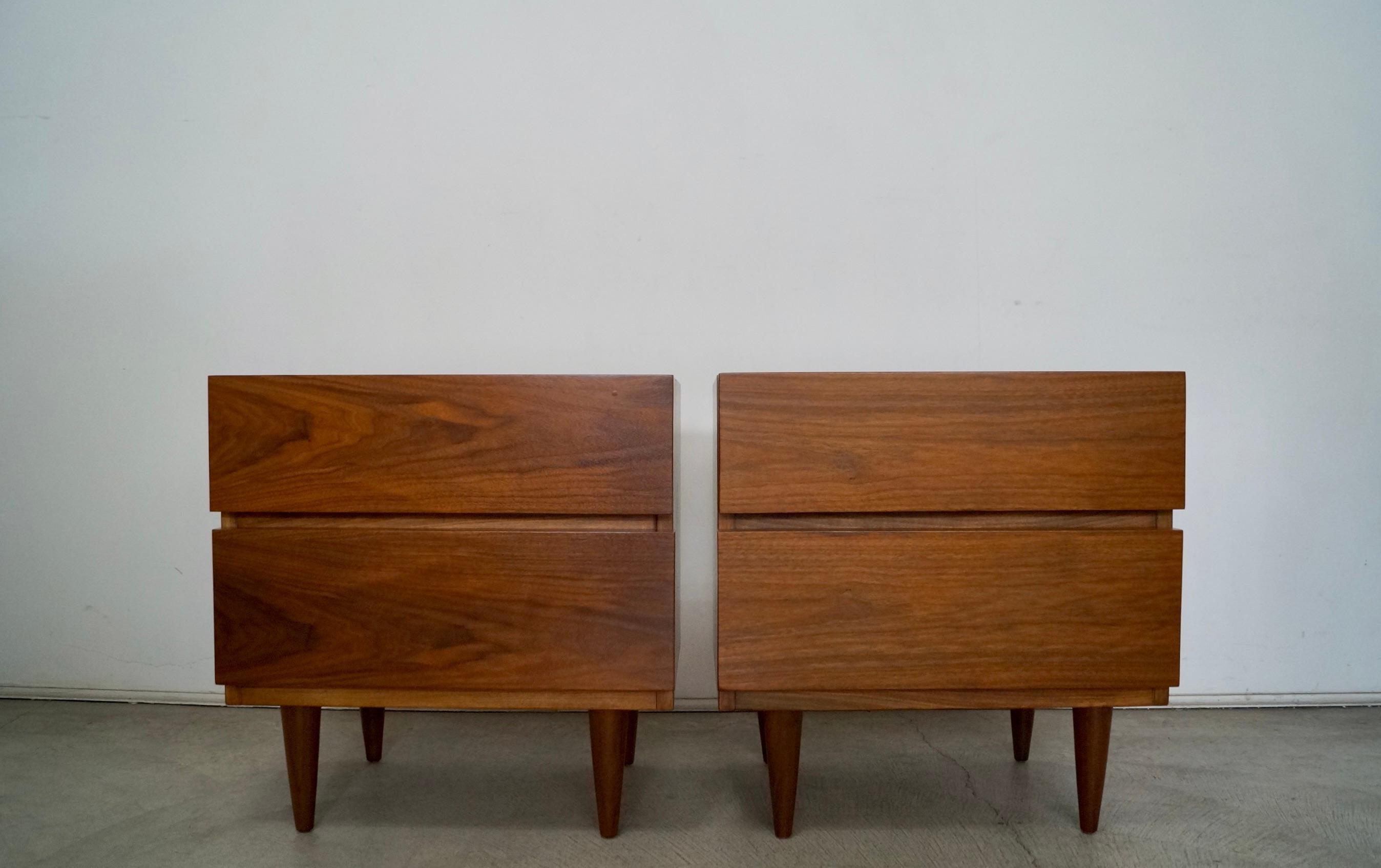 Vintage 1960s Mid-Century Modern pair of night stands for sale. Manufactured by American of Martinsville, and have been professionally refinished. They are really well made, and have a clean design. The walnut grain on these is very beautiful. We