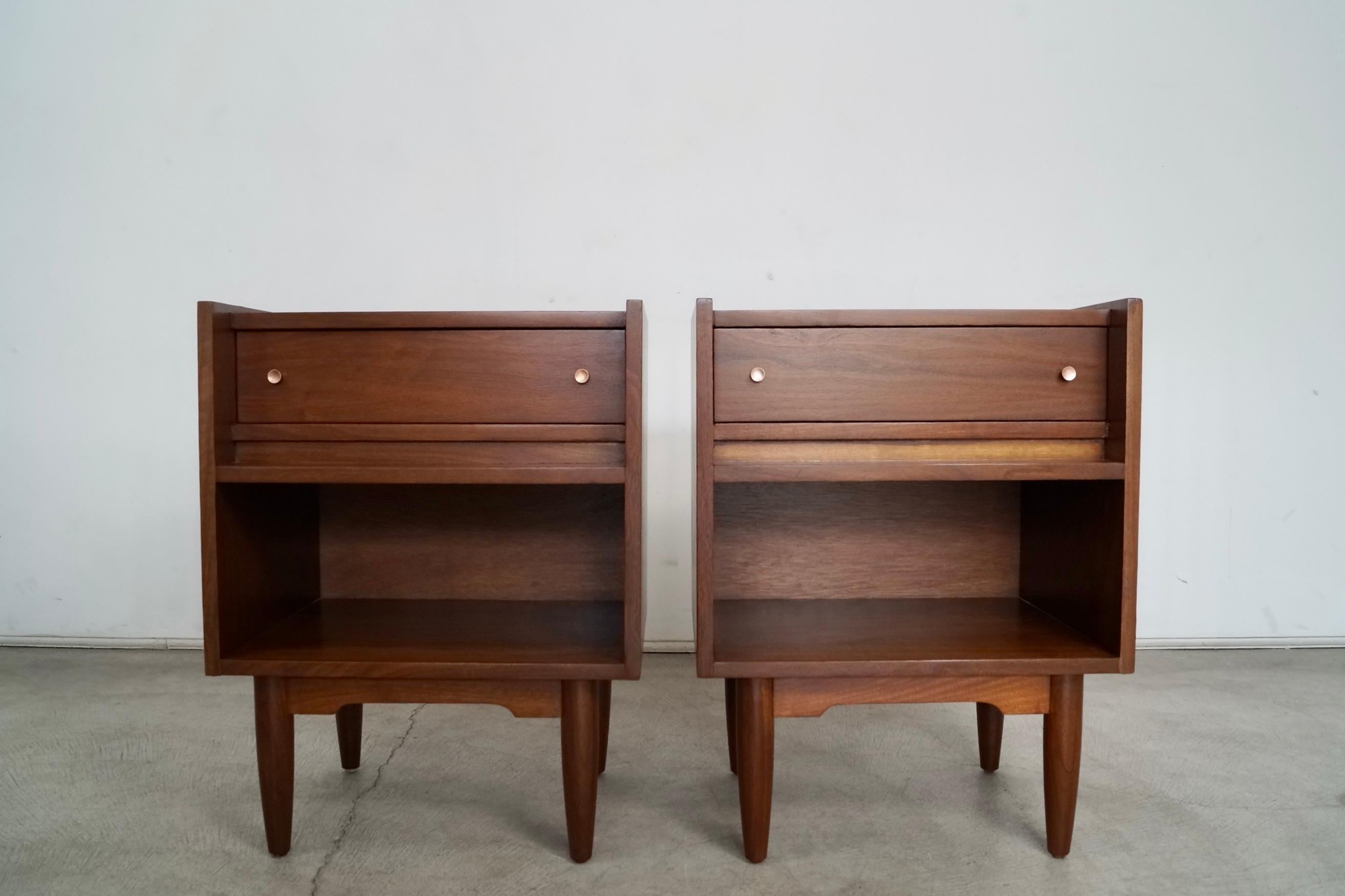 Pair of original vintage Mid-century Modern night stands for sale. They have a very unique design, and have been professionally refinished. They are made of walnut, and are high-quality bedside tables. They have a drawer that is dovetailed on both