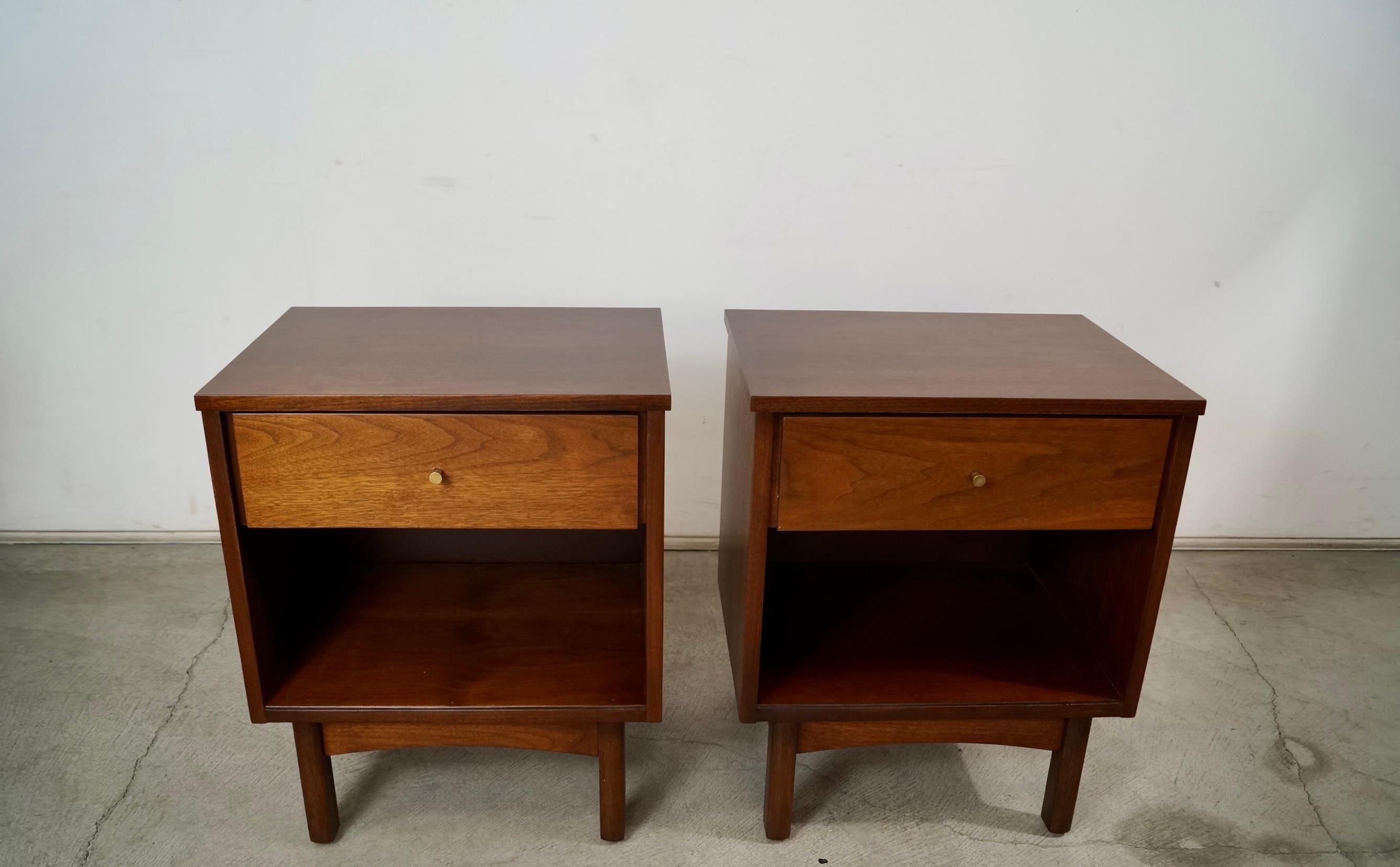 Pair of original vintage Midcentury Modern night stands for sale. From the 1960's, and have been refinished. They're solid and well constructed, and made of walnut. They have a teardrop brass knob, and have one single drawer and open shelving. The