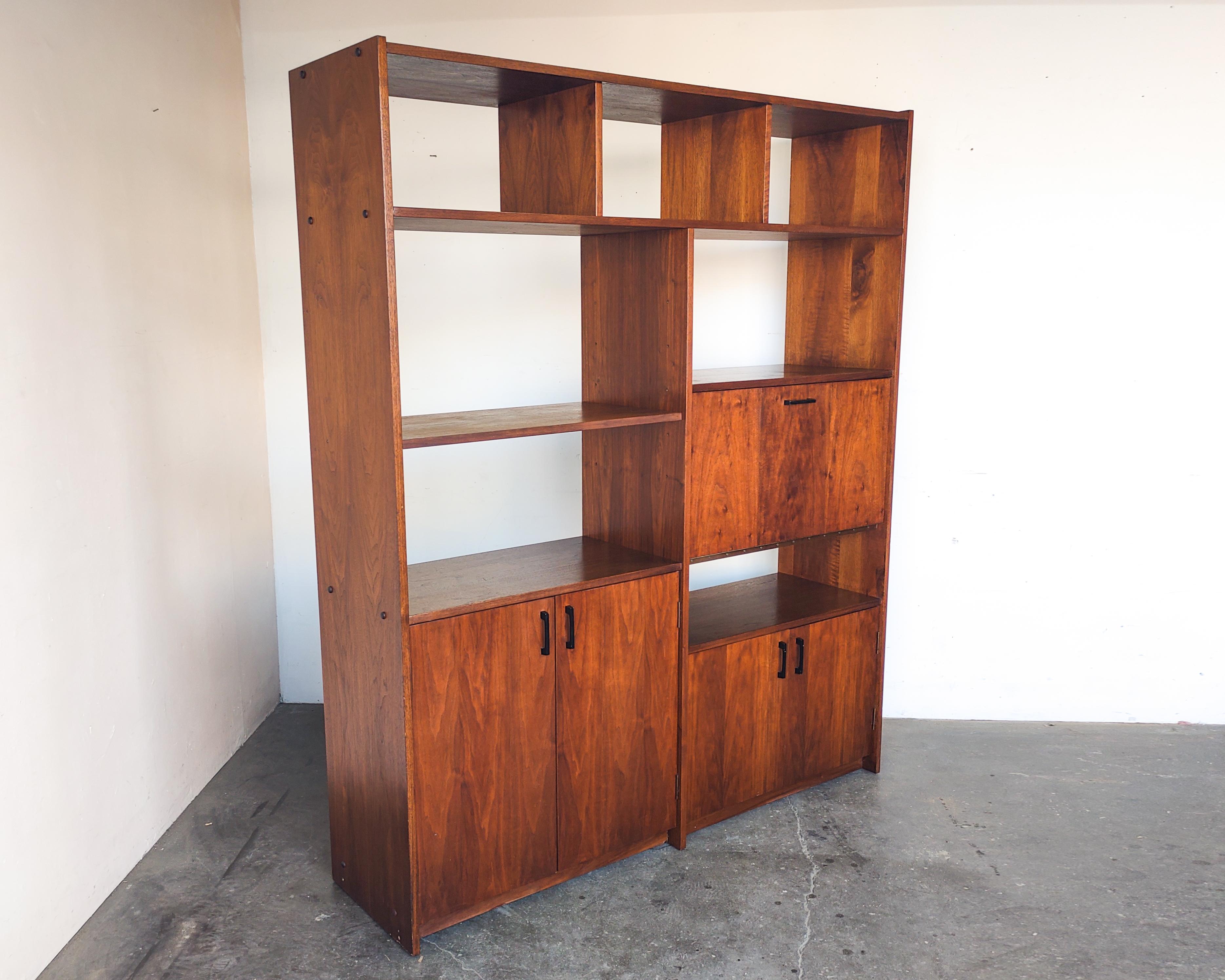 Walnut shelving wall unit with drop-down writing desk and black hardware. Cabinet storage on left has an adjustable shelf inside. Open shelf on left is also adjustable. Finished on the back, can drill holes for wires after purchase upon request.