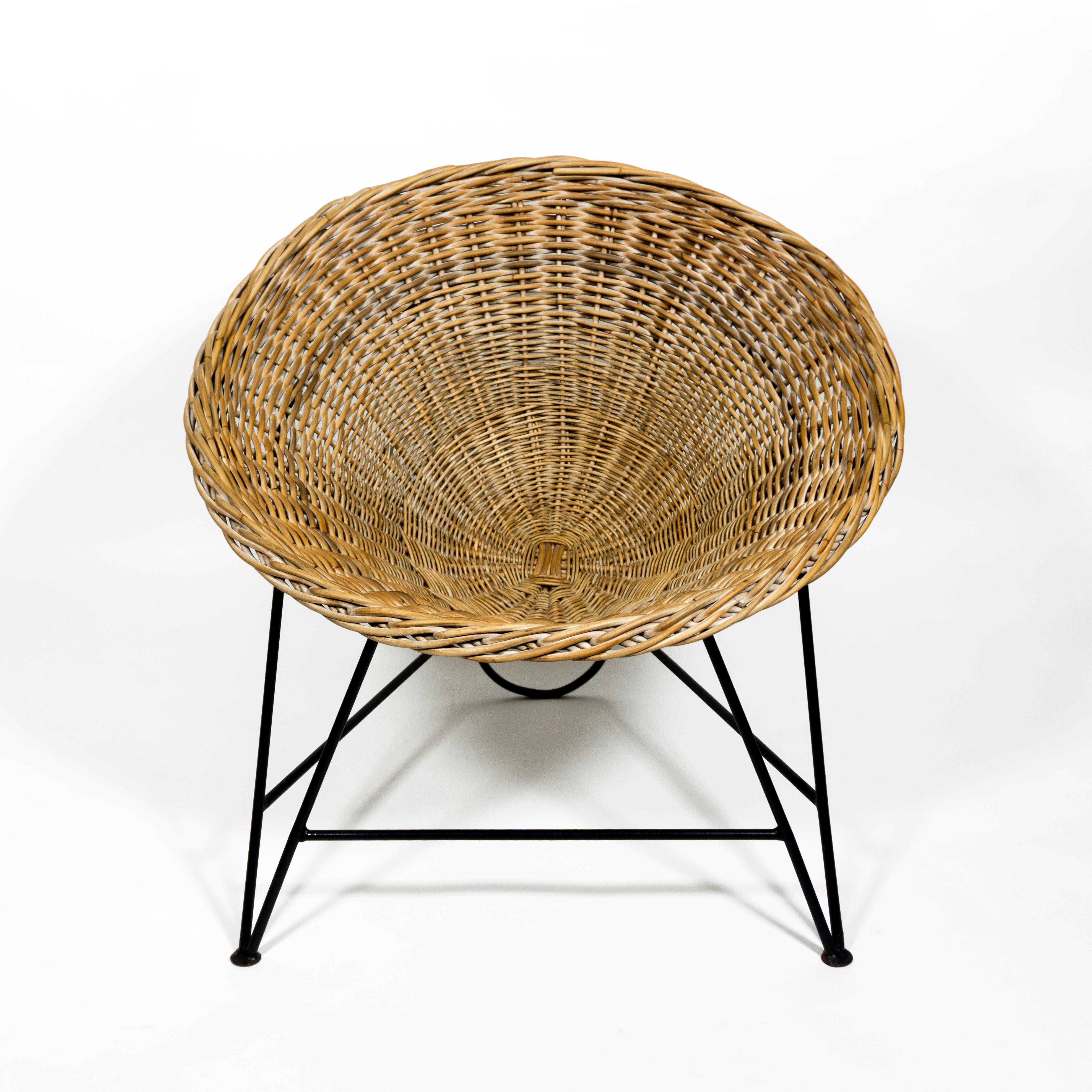 Beautiful vintage rattan basket chair with iron base from the 1960s. 
The chair has a woven rattan seat shell and a lacquered iron frame. The seat is loose and can be removed from the base.
This beautiful chair would be a perfect addition to your